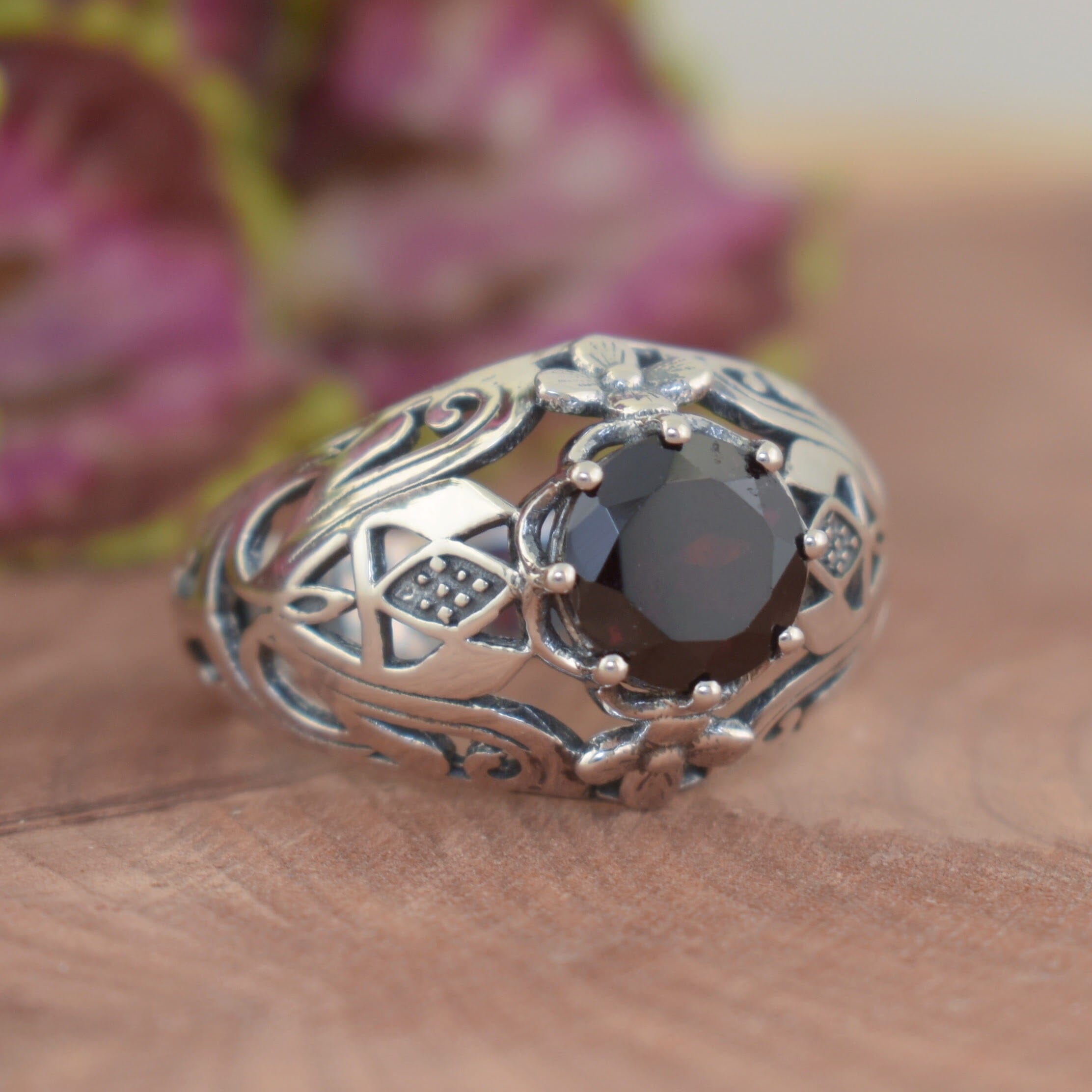 hand crafted sterling silver ring with a prong set Garnet stone