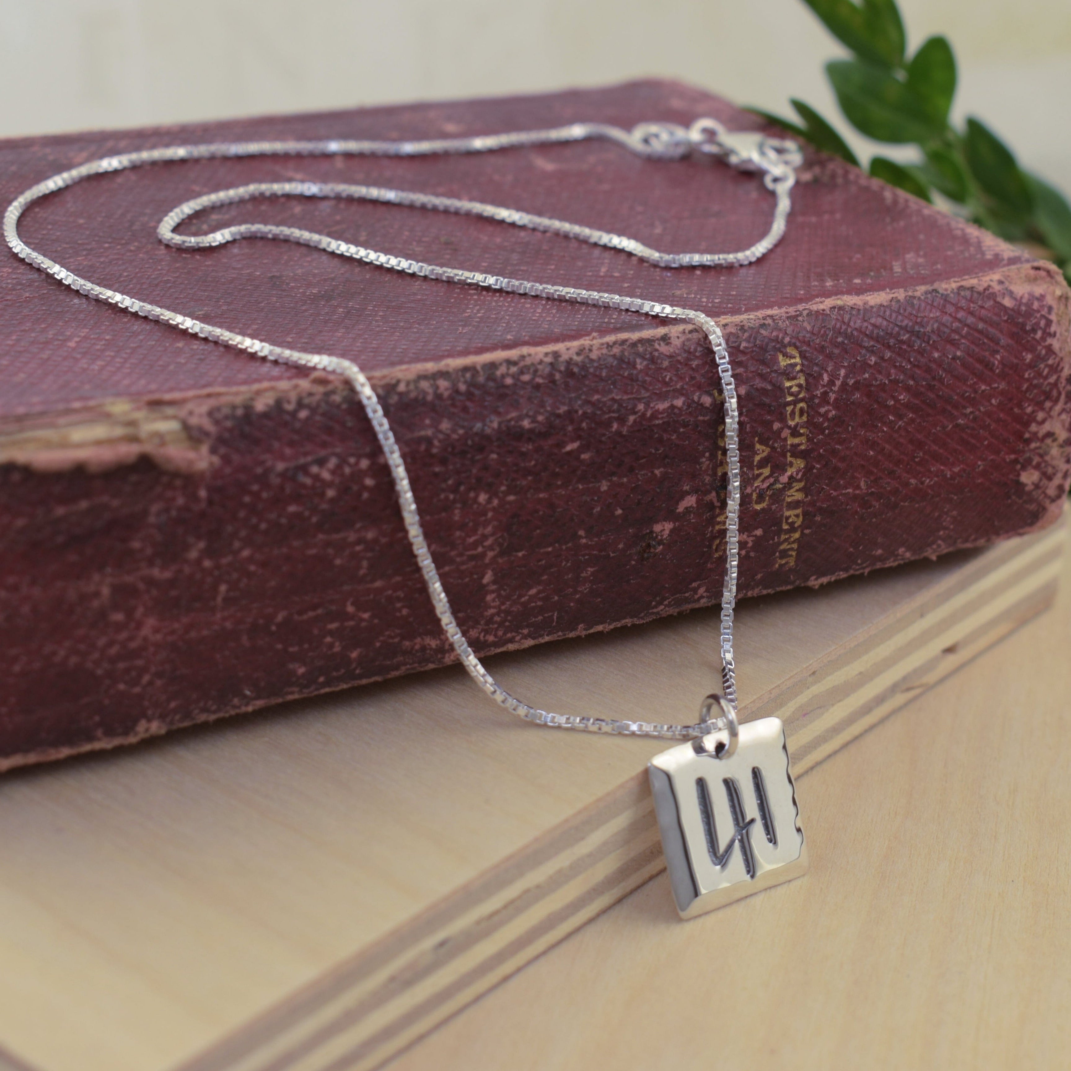Christian inspired necklace featuring a silver square pendant engraved with the number 41