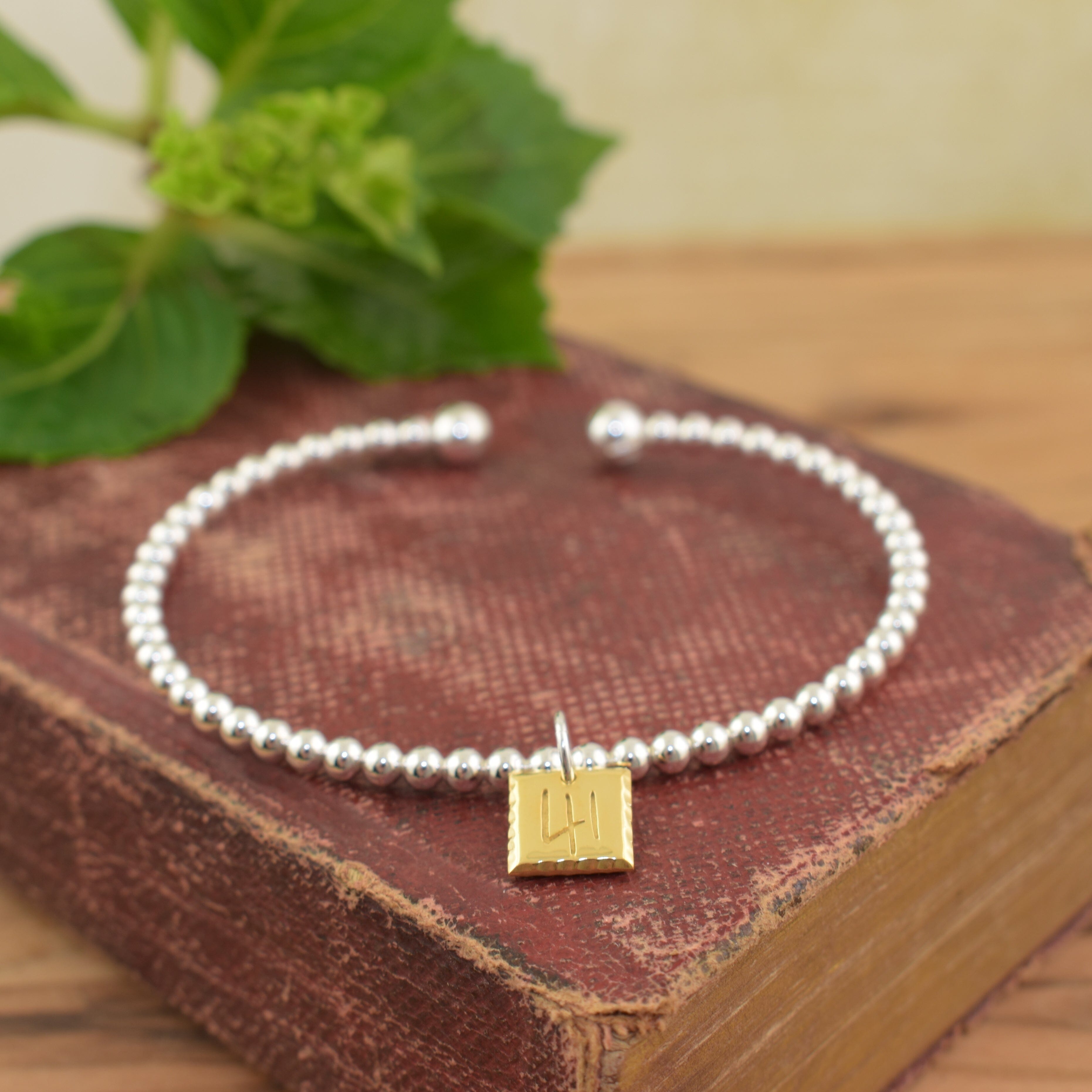 Christian inspired cuff bracelet featuring a gold plated pendant engraved with the number 41