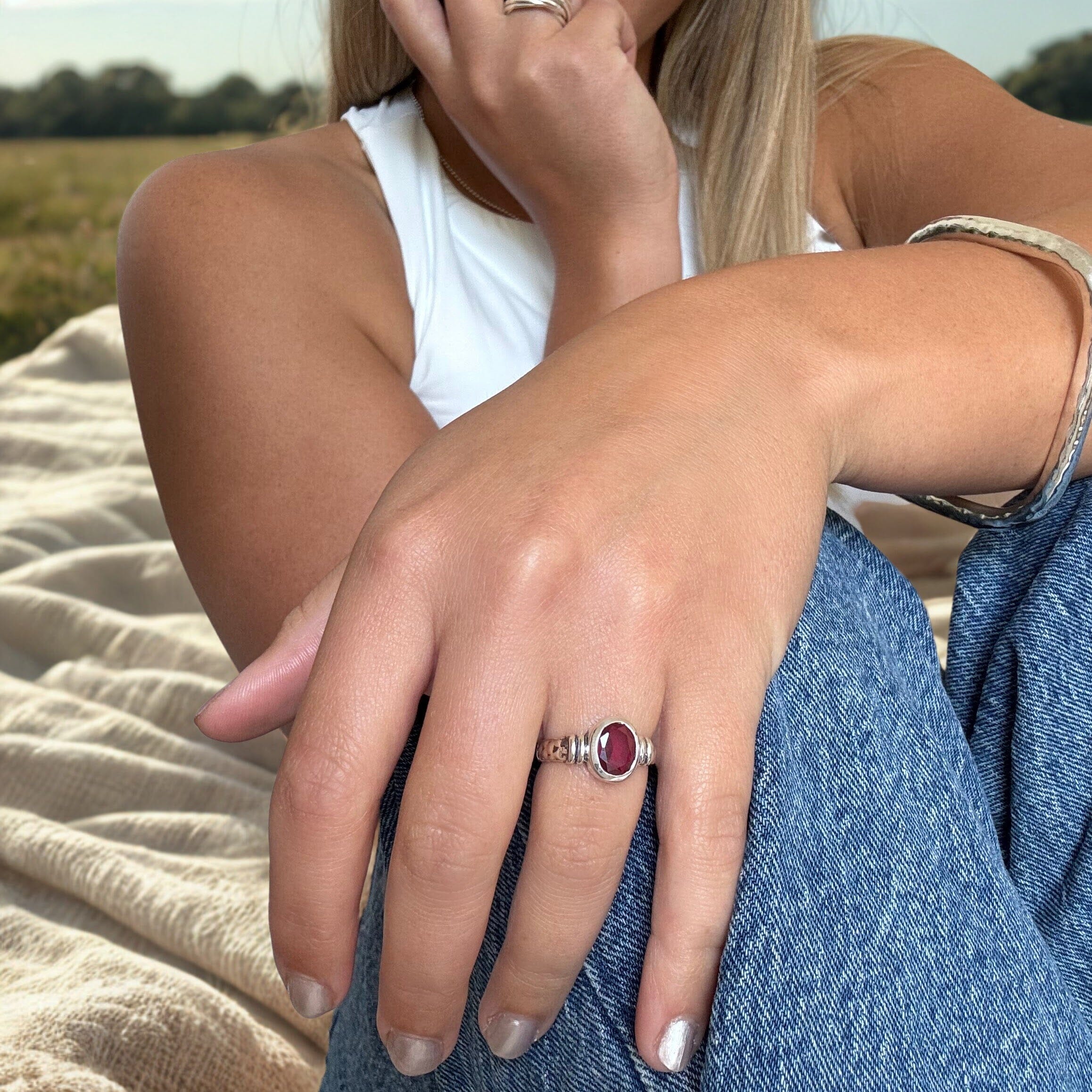 antiqued sterling silver ring featuring an oval ruby colored stone