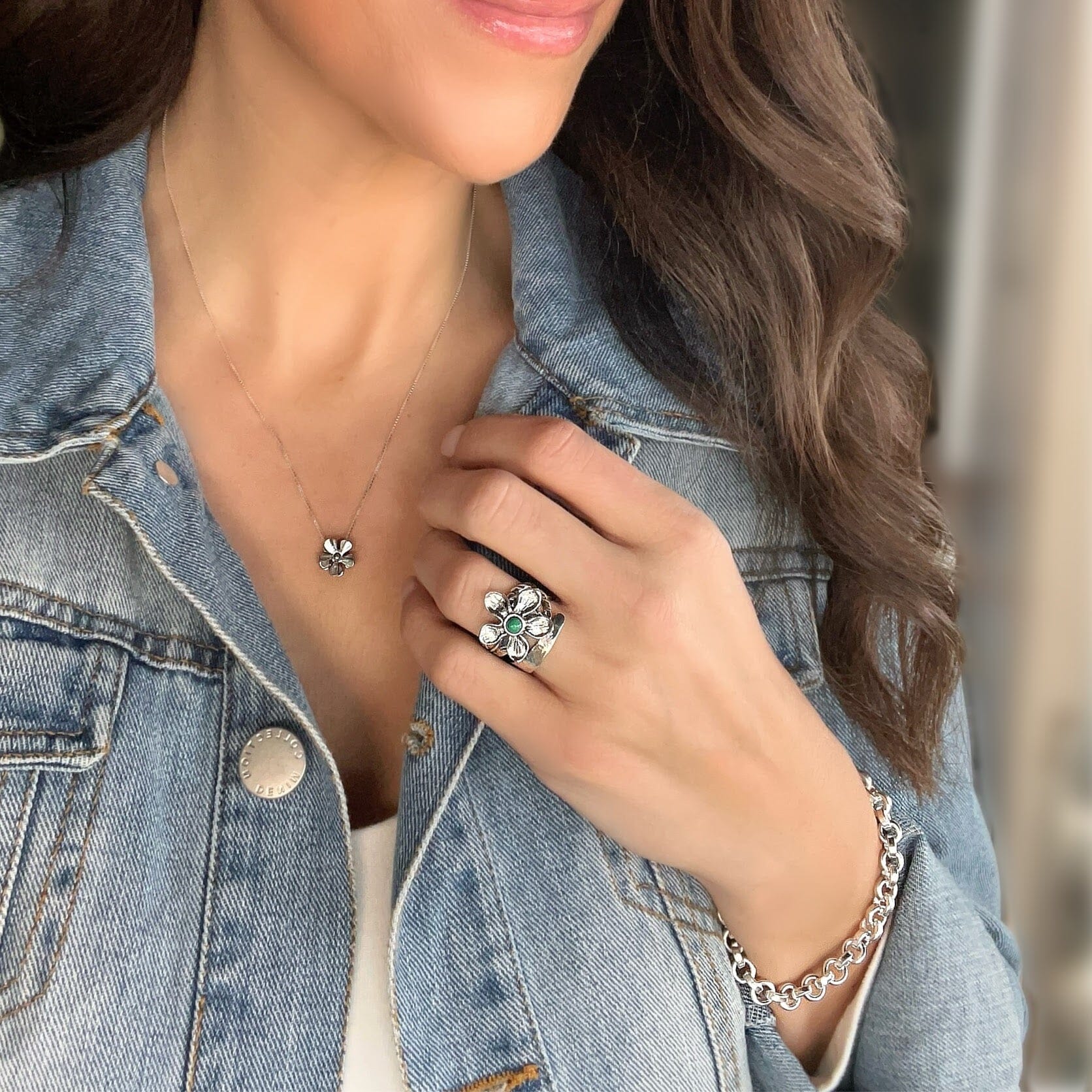 sterling silver ring with a raised flower design and a turquoise stone in the center paired with Bonita bracelet and Susannah necklace