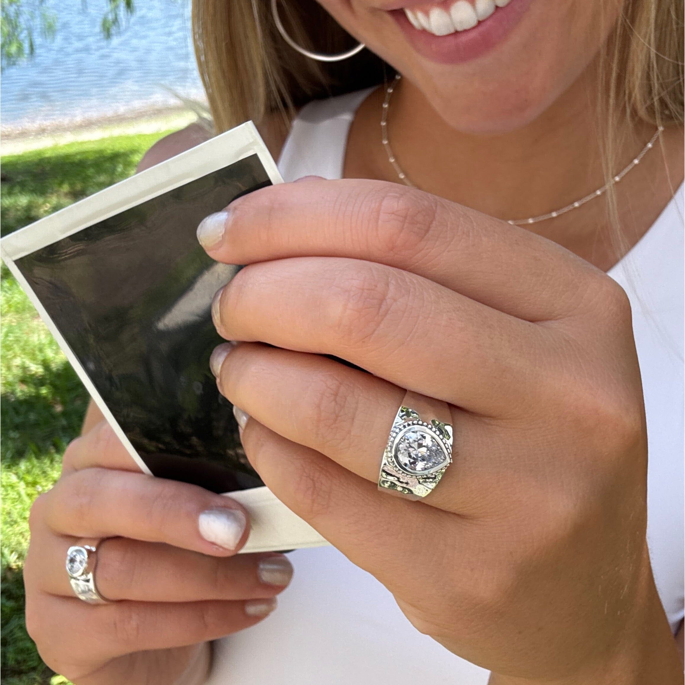 wide hammered ring featuring a cubic zirconia stone bezel-set in a pear-shaped setting