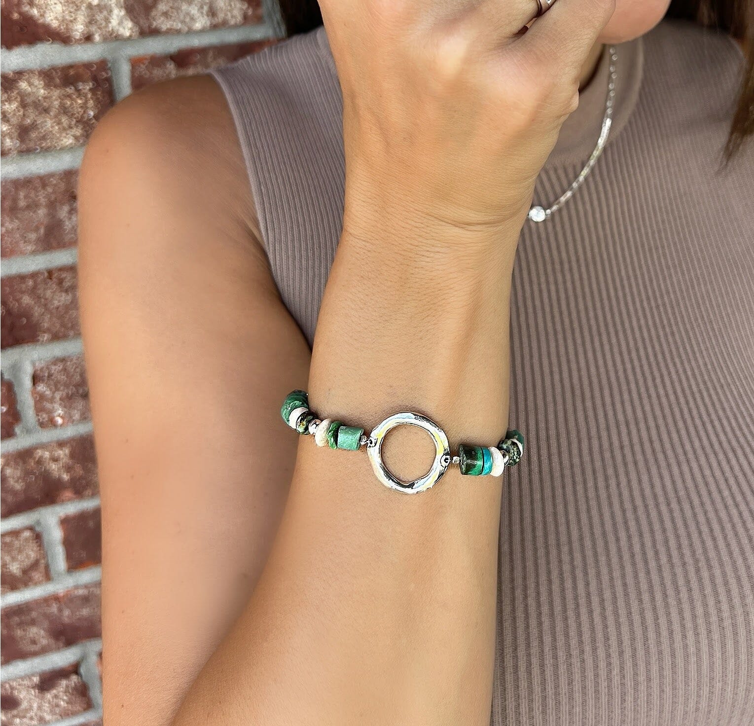 Handcrafted turquoise bracelet with a round silver piece on the bracelet