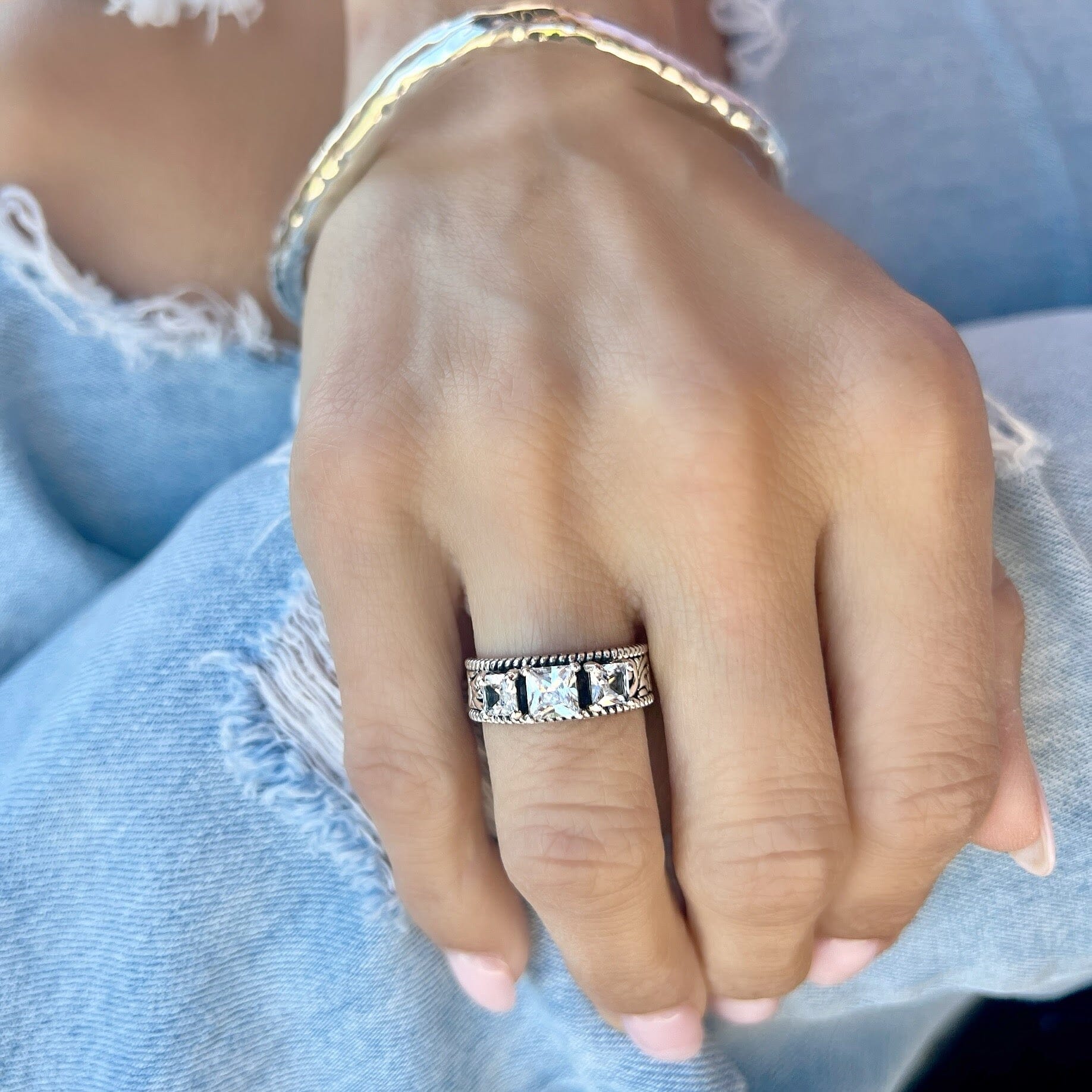 sterling silver ring with a western detailed band featuring three CZ stones