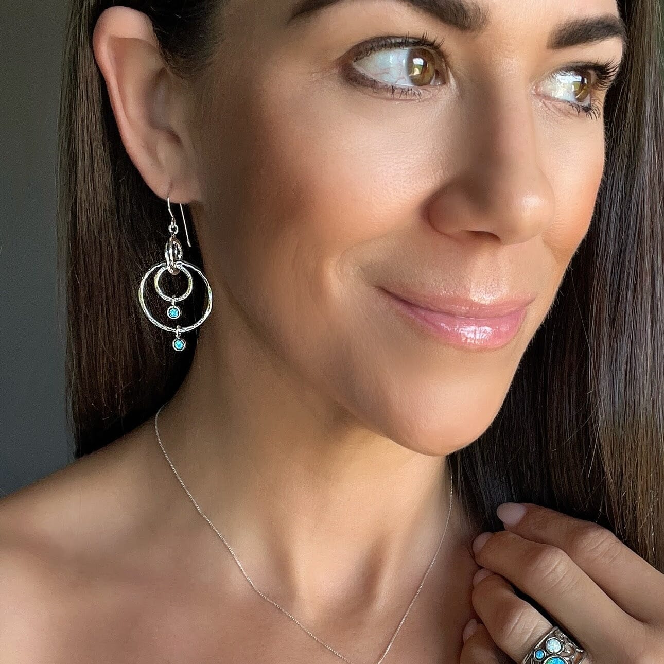 silver dangling earrings featuring three hoop dangles and two opal dangles