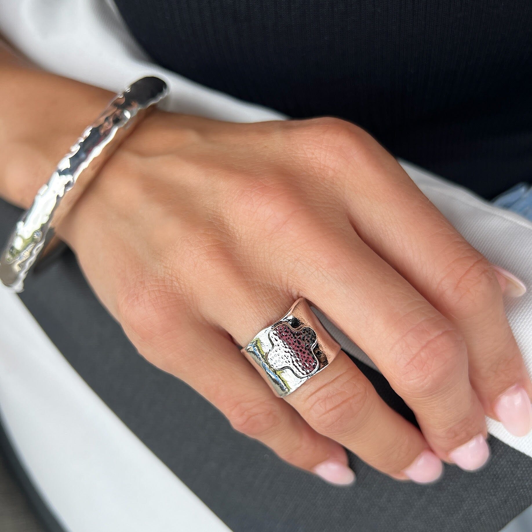 designer piece, featuring a wide band and a striking central cross