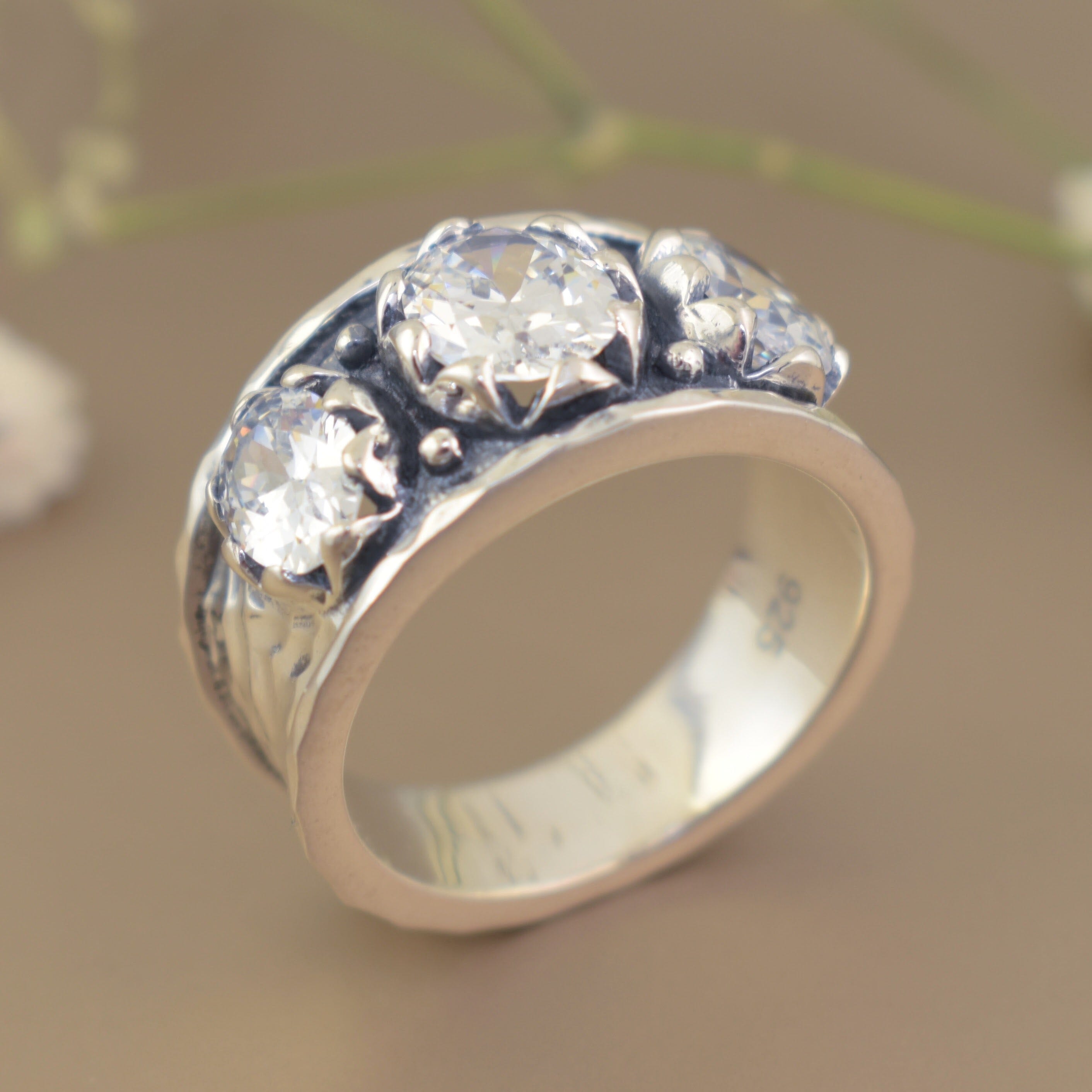 high polished hammered band with an oxidized finish on top with three cubic zirconia stones