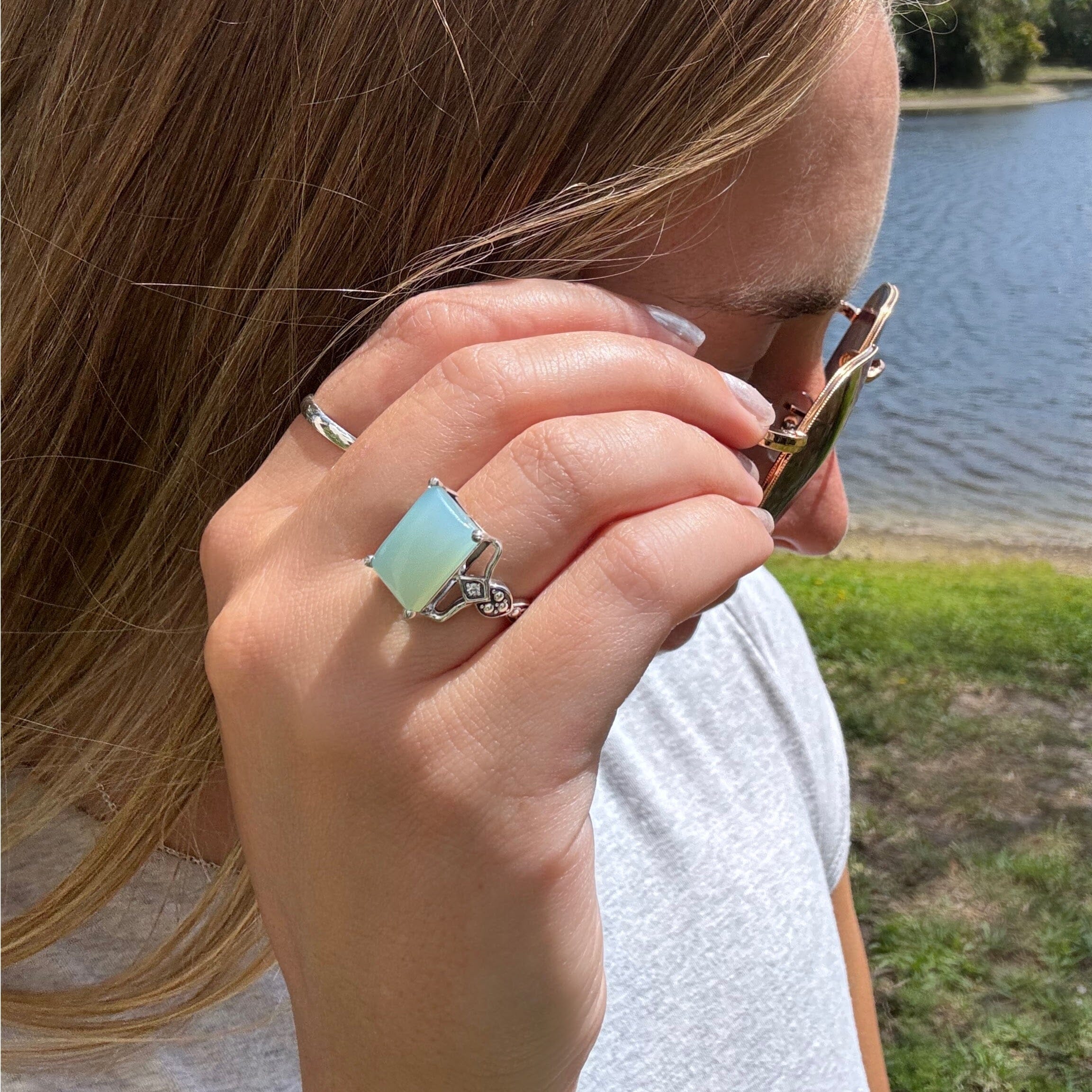 Aqua chalcedony prong-set in a handcrafted sterling silver ring with CZ accent stones on the band