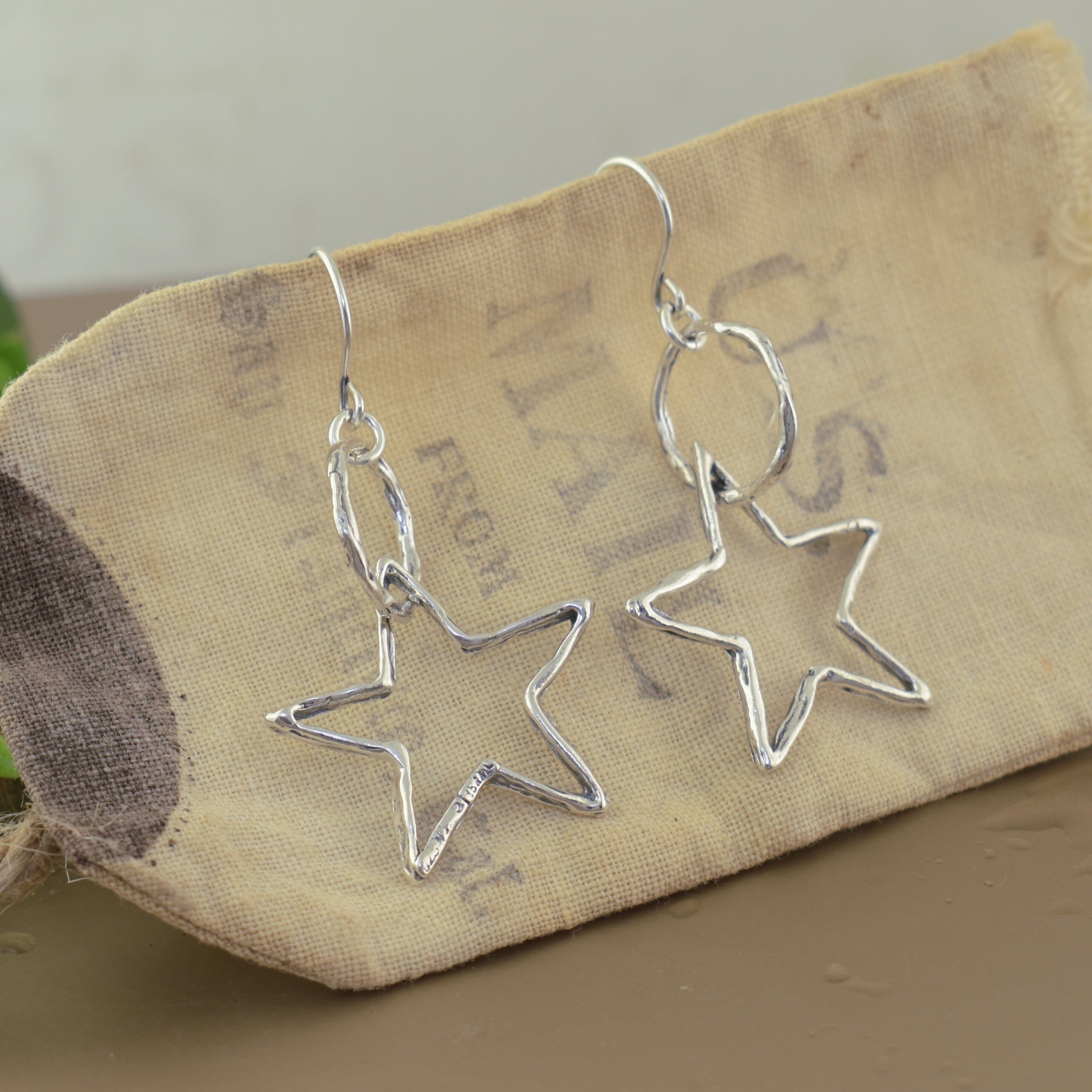 Silver star-shaped earrings on French hooks