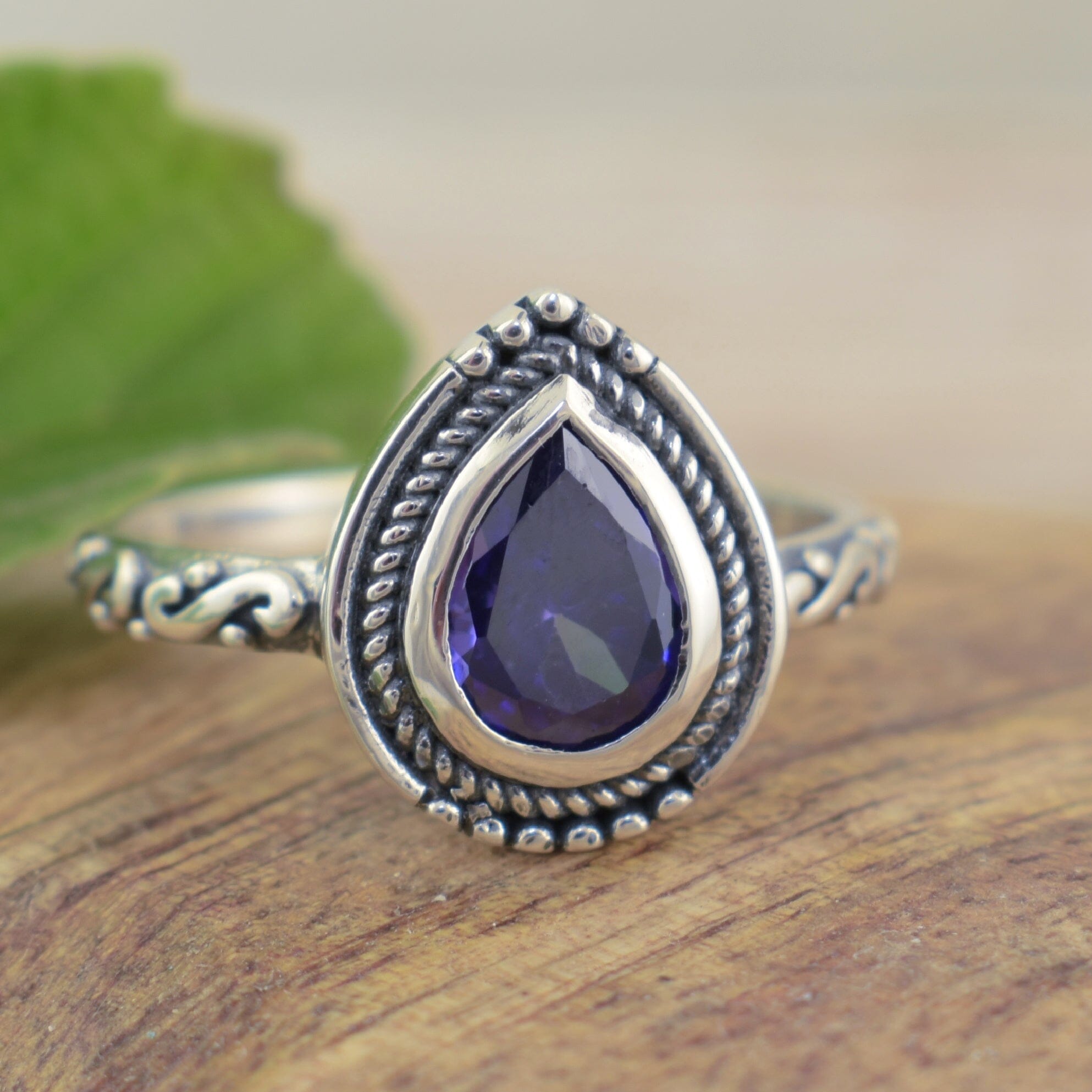 Old-world inspired ring featuring polished sterling silver and purple pear shaped cz stone