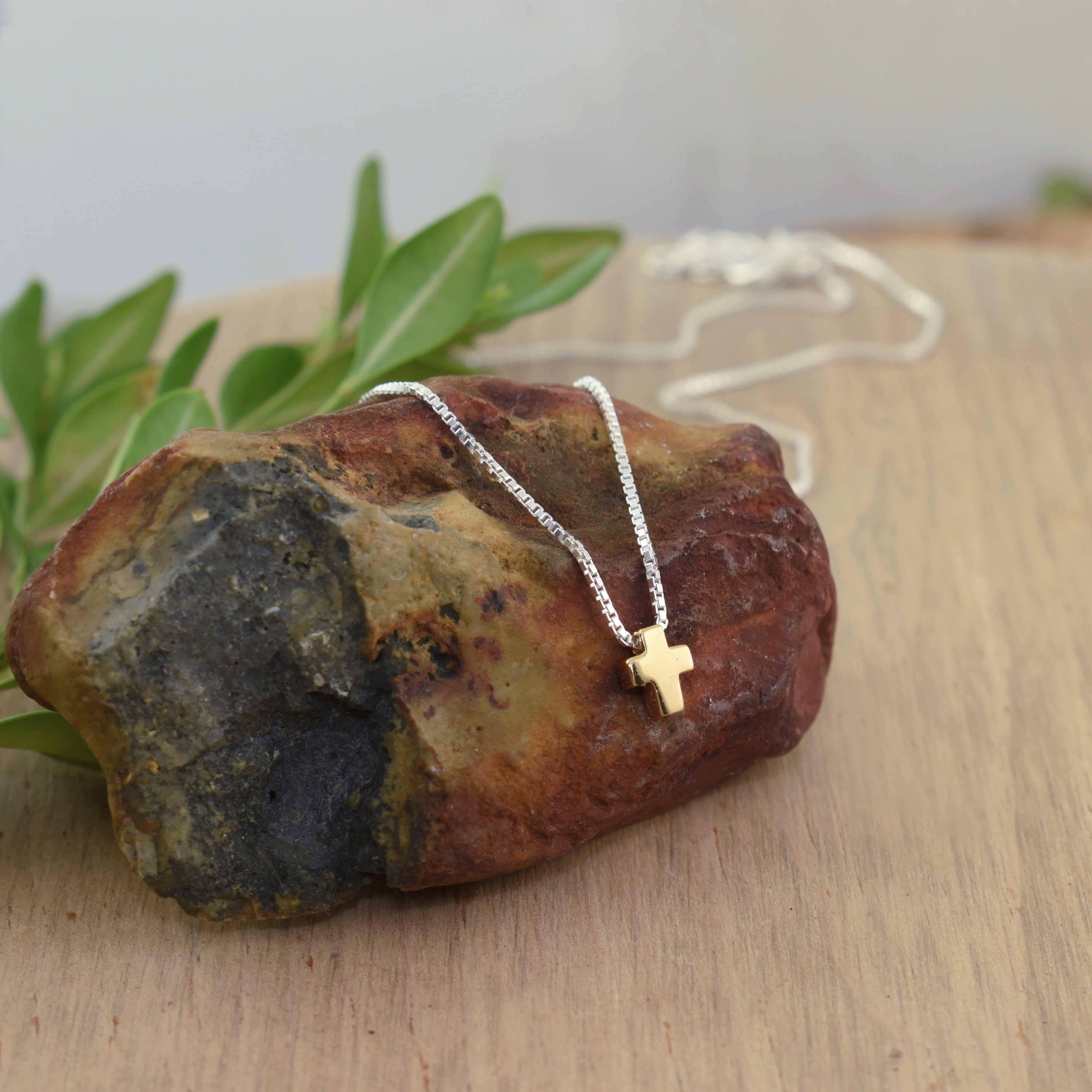 silver necklace featuring a dainty gold-filled cross