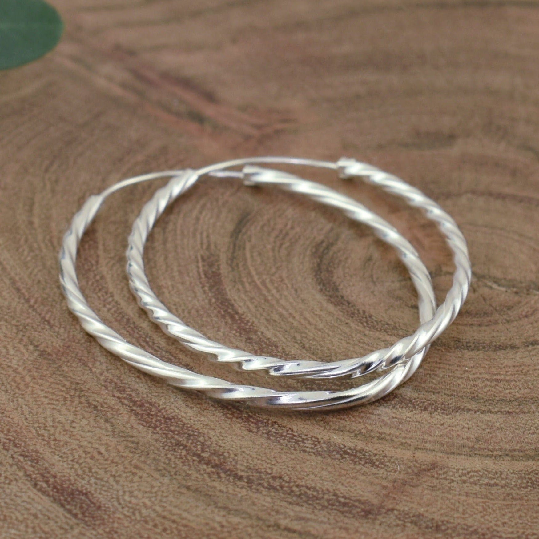thin oval hoop earrings with twist design