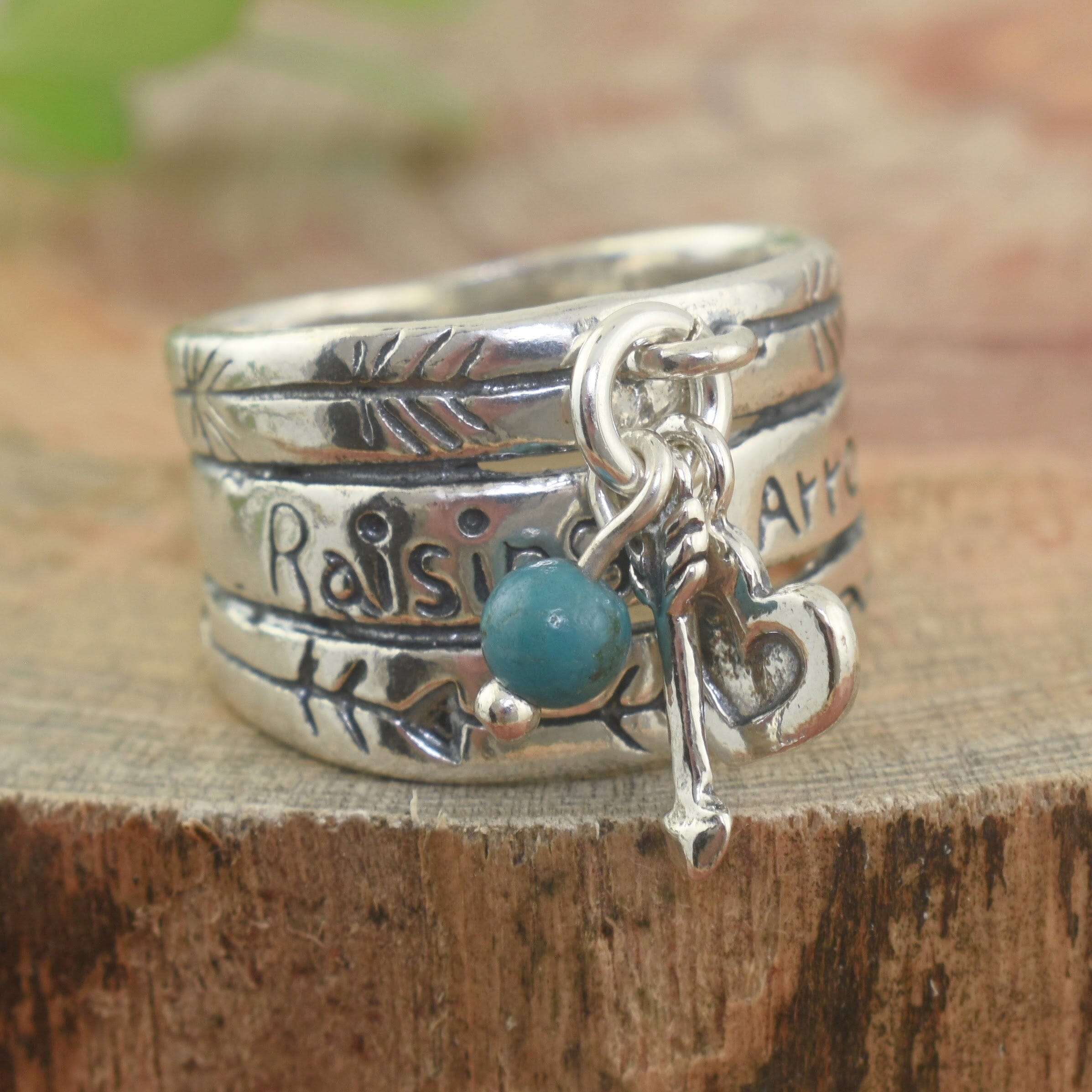 Sterling silver ring inscribed with phrase "Raising Arrows"