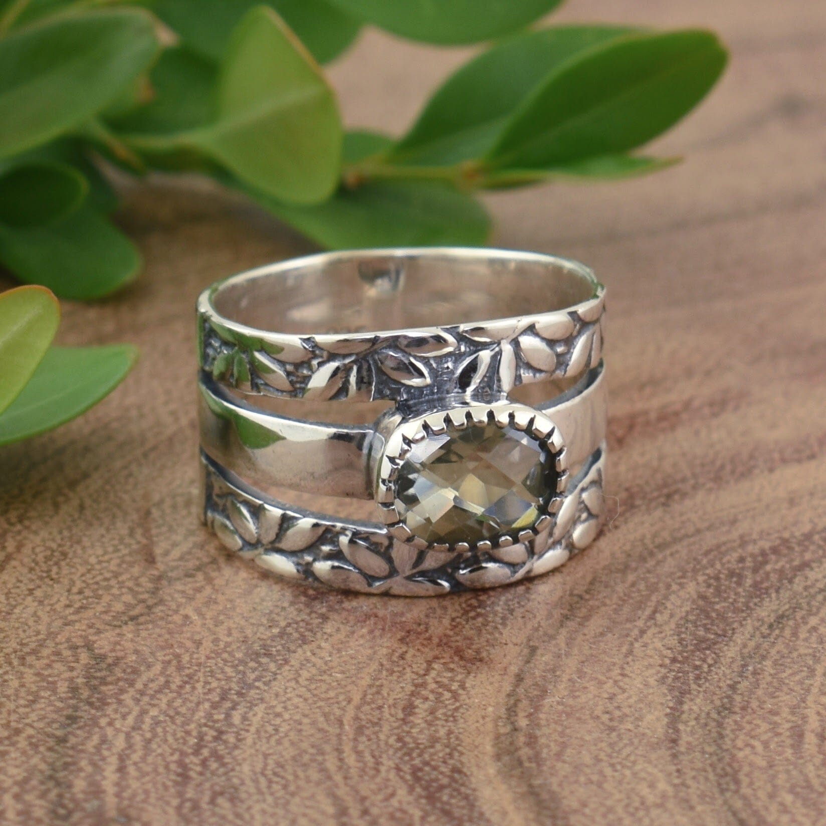 .925 sterling silver ring with a botanical design and an oval light green amethyst stone