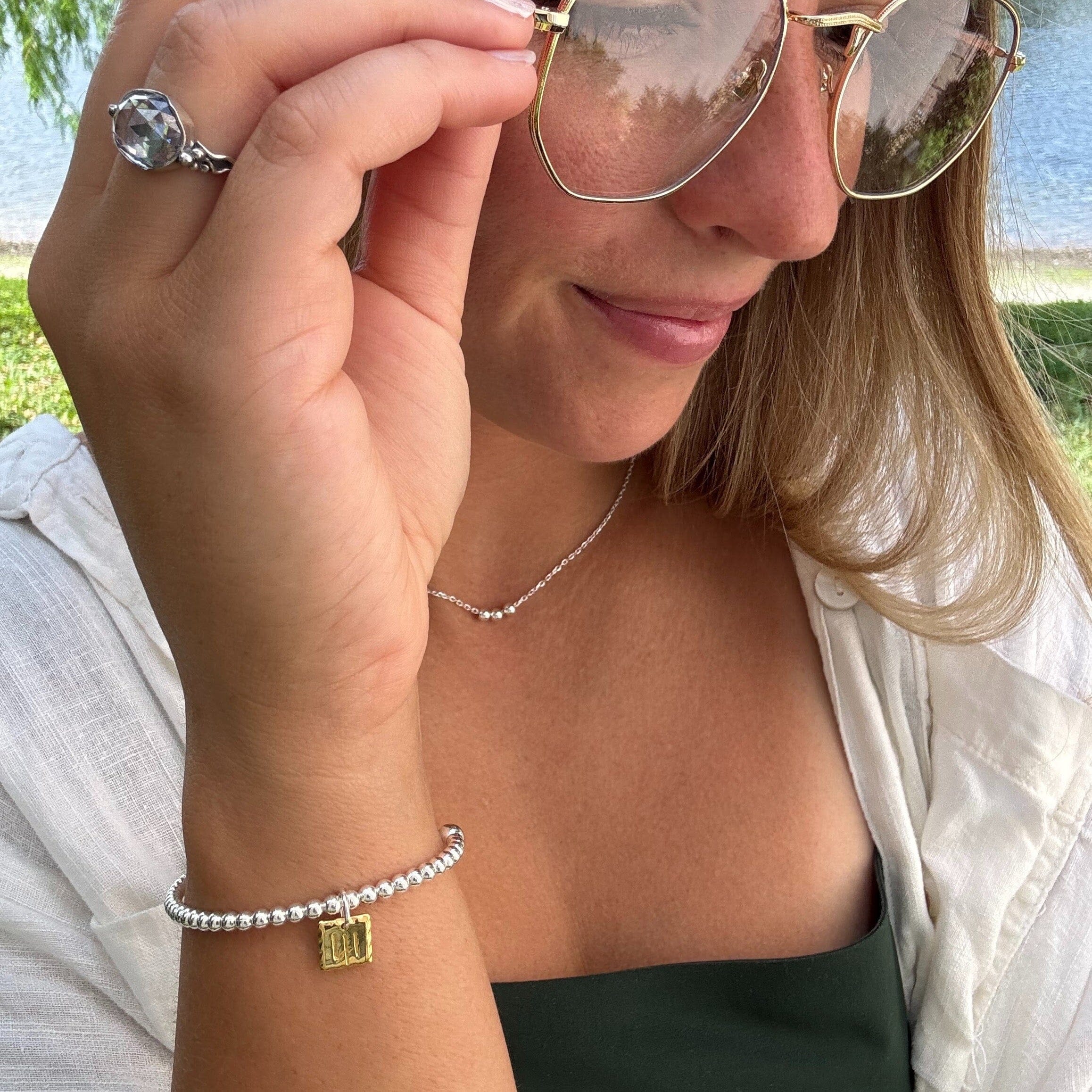 41 Bracelet in gold paired with sterling silver Joy Necklace and Light of Mine Ring