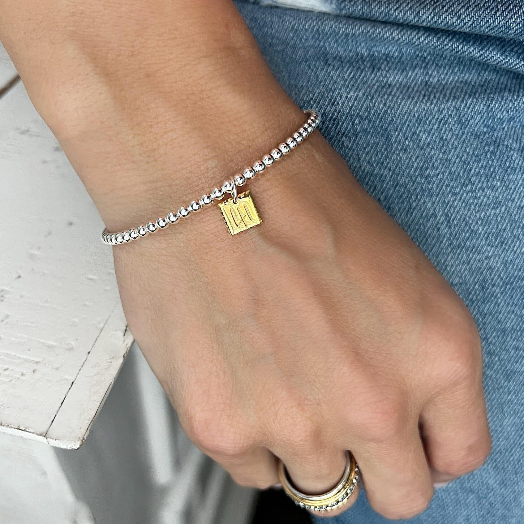 silver beaded cuff featuring a 14K gold plated pendant engraved with the number 41