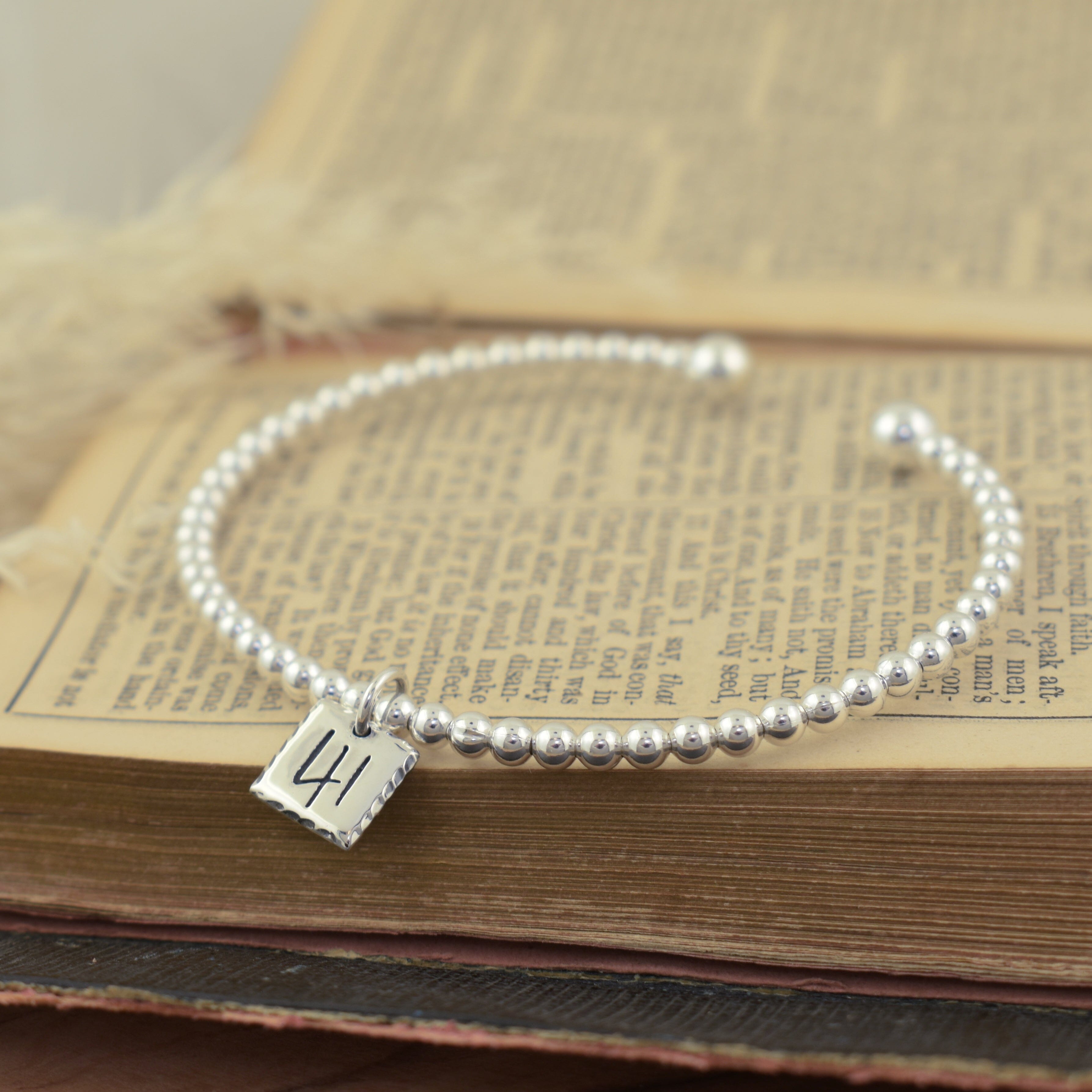 Christian inspired cuff bracelet featuring a silver square pendant engraved with the number 41