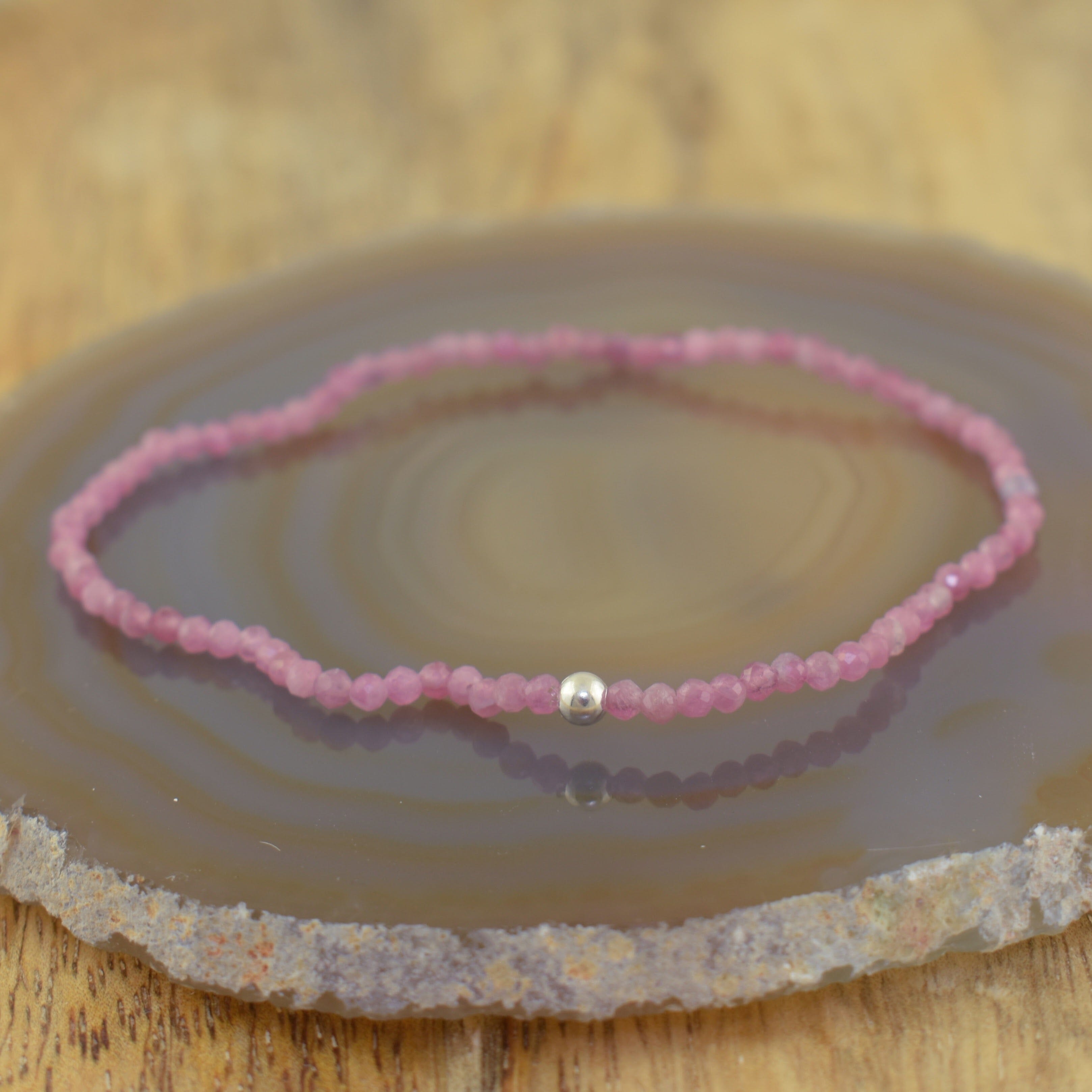 a pink beaded stretch bracelet with a single silver spacer bead