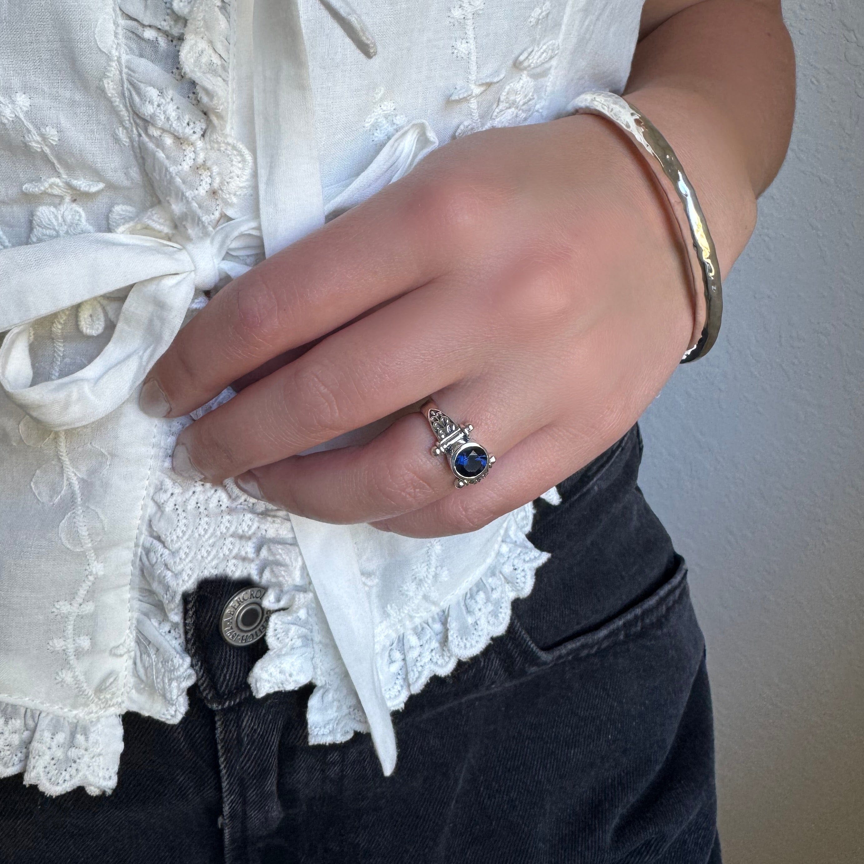 sterling silver designed ring featuring a blue cz stone paired with the essentials bracelet. 