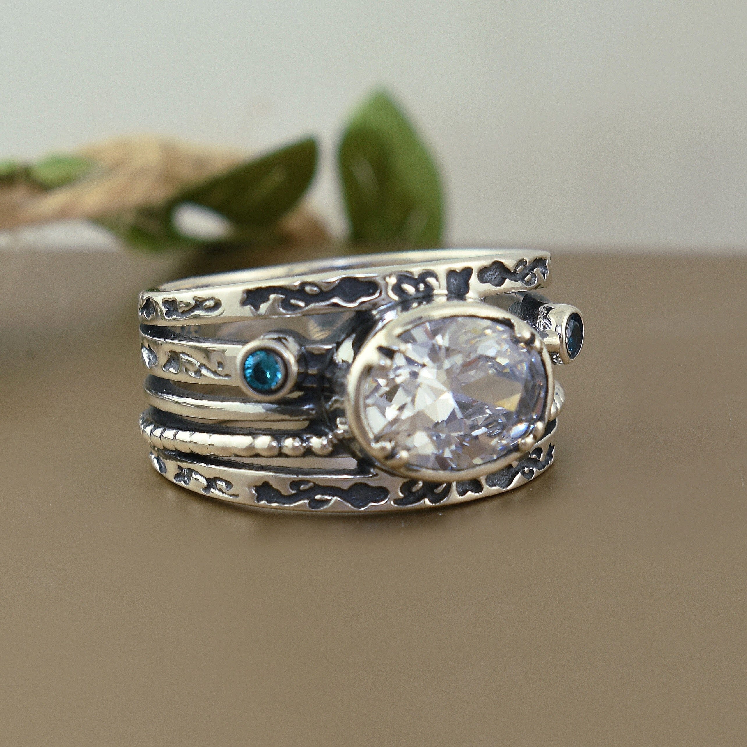 Sterling silver ring with oval shaped clear cz and round blue cz accents stones