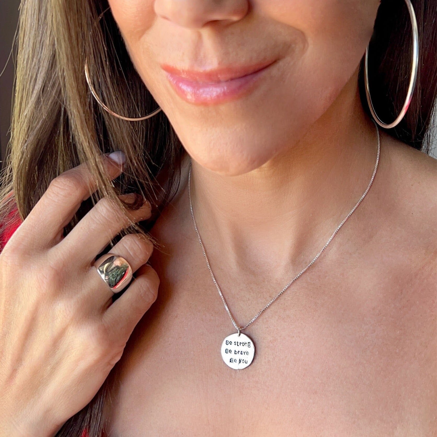 inspirational sterling silver pendant stamped with "be strong, be brave, be you" on a delicate chain