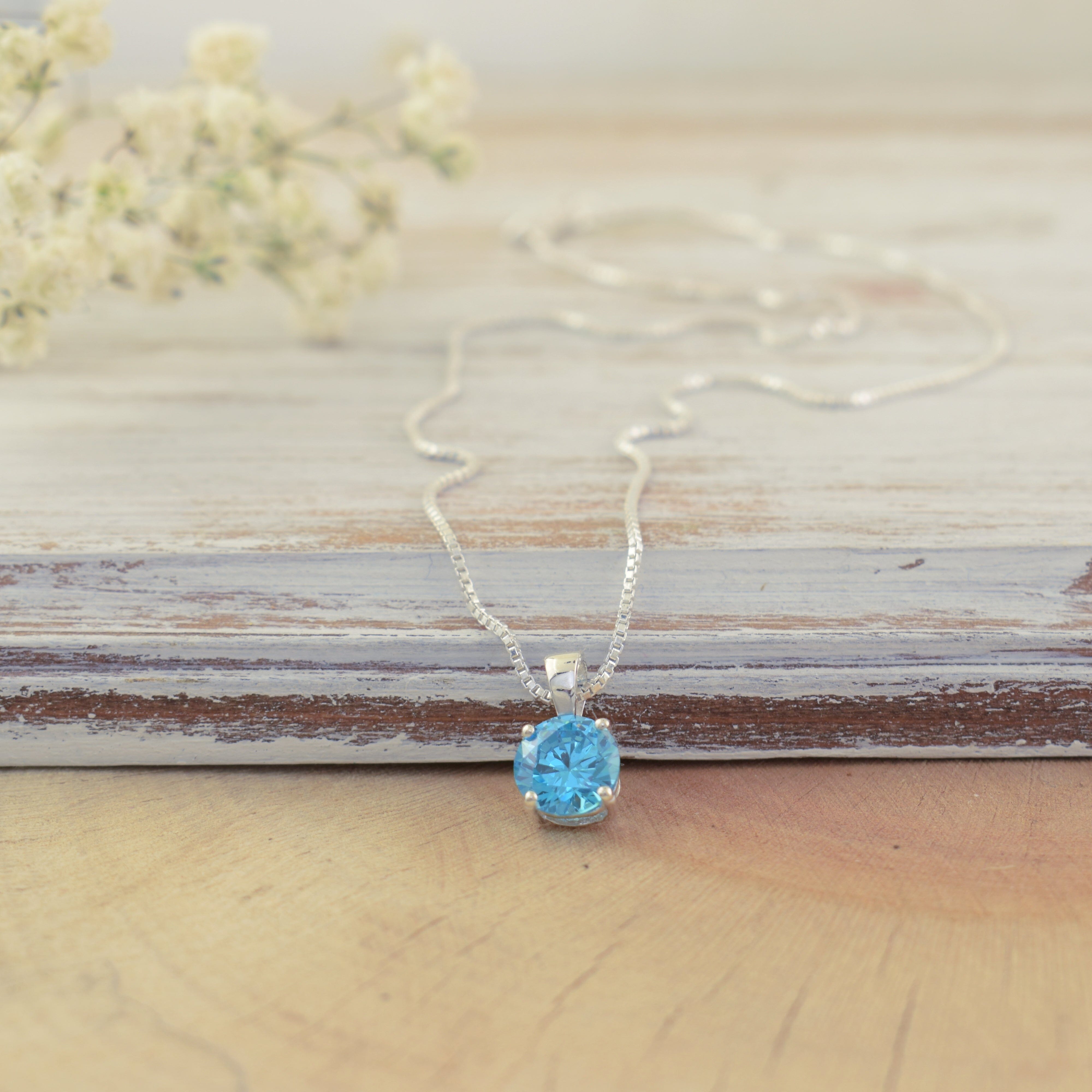 delicate sterling silver necklace with a prong-set aqua cz stone pendent