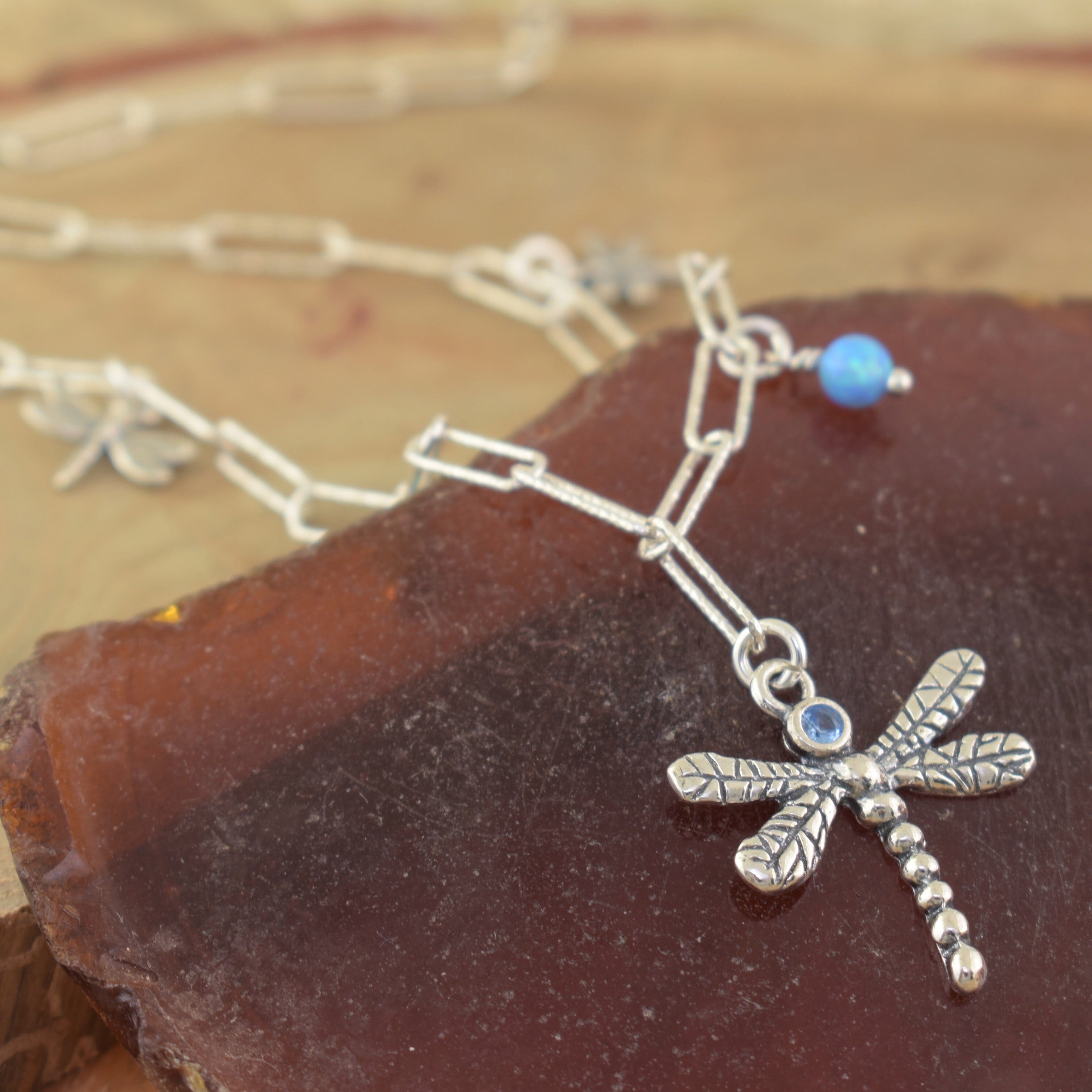 Reconstructed opal beads with a dragon fly and a bezel set blue topaz stone