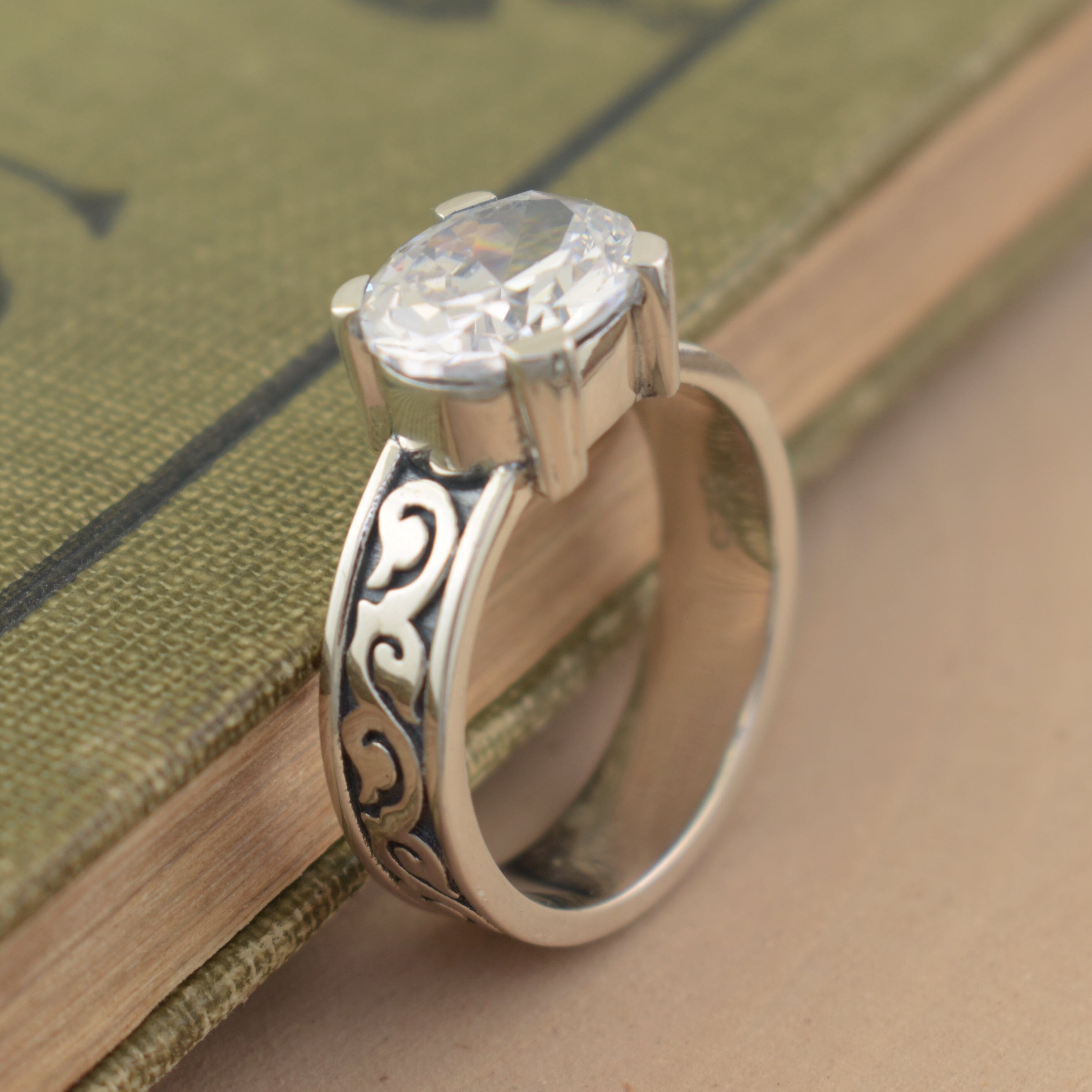 oxidized sterling silver band with swirls featuring a prong-set center stone