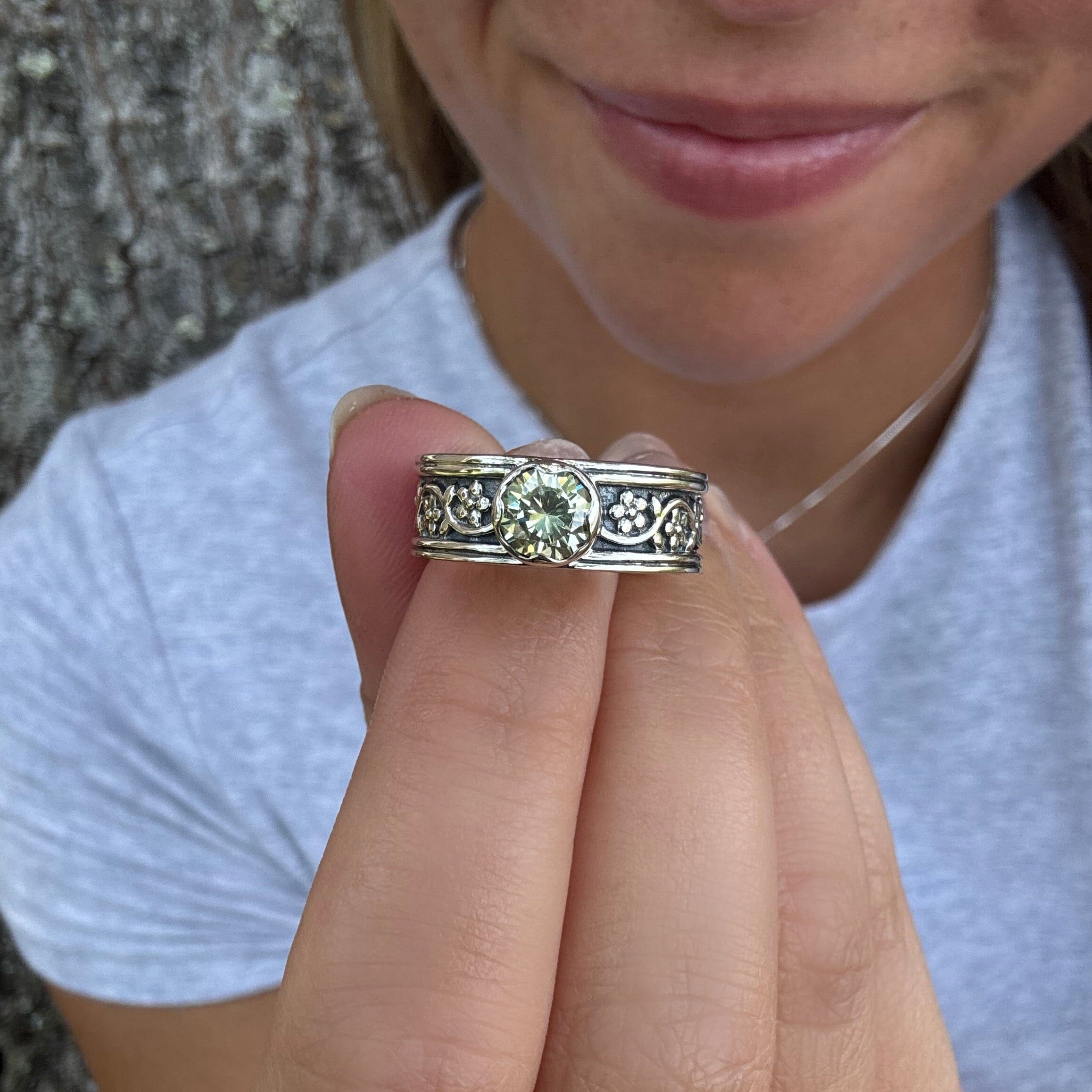 sterling silver ring with a detailed band featuring a light peridot stone