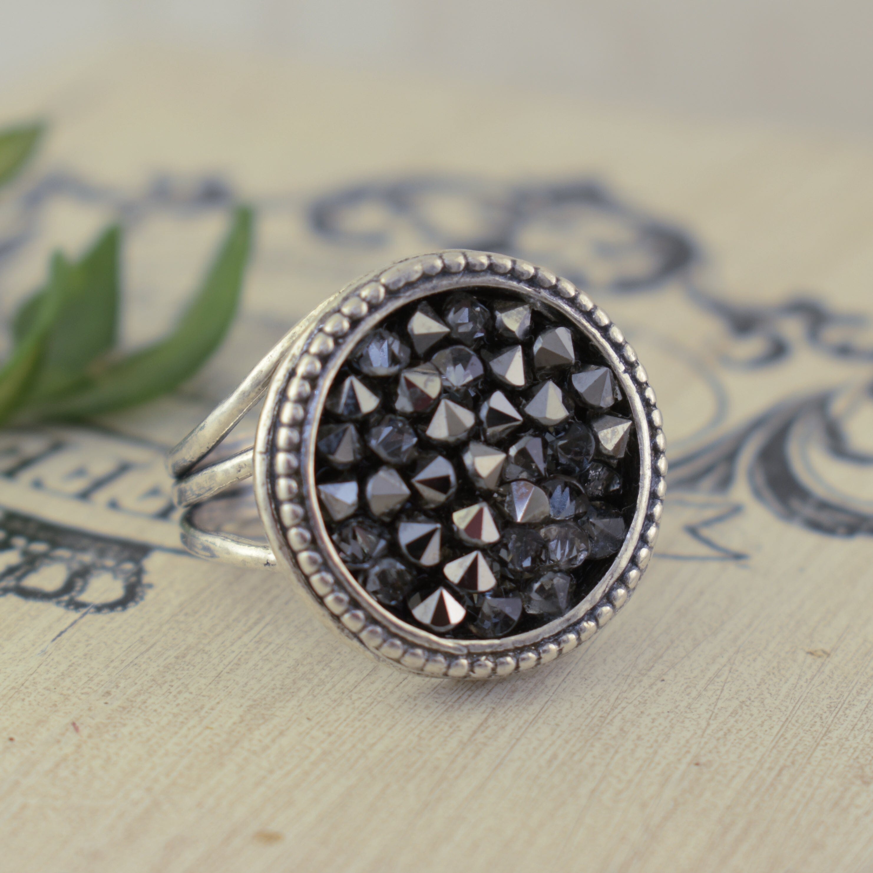 large round silver ring featuring black Austrian crystals set in a beaded bezel frame