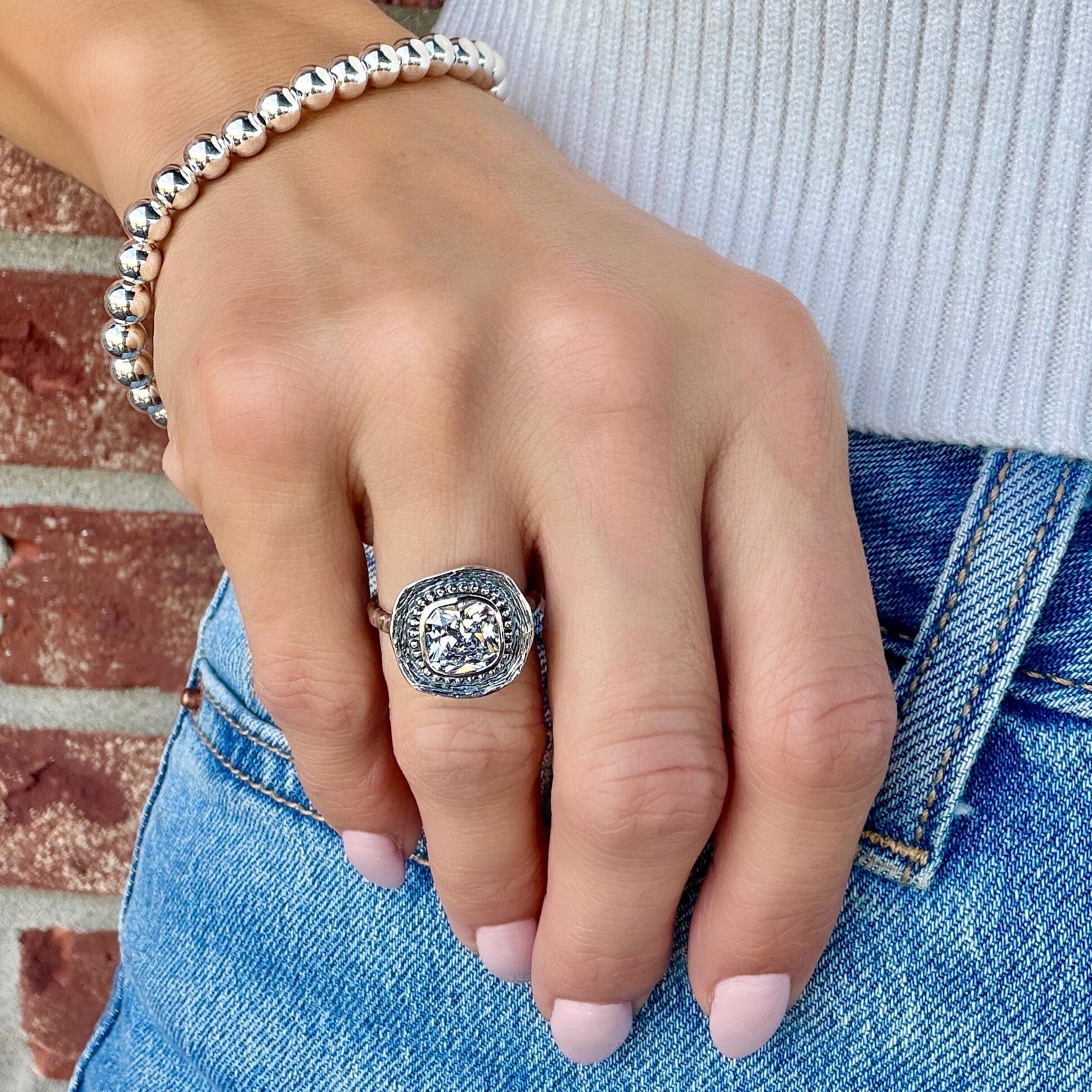 unique sterling silver ring with textured and beaded framing surrounding a cushion-cut cz 