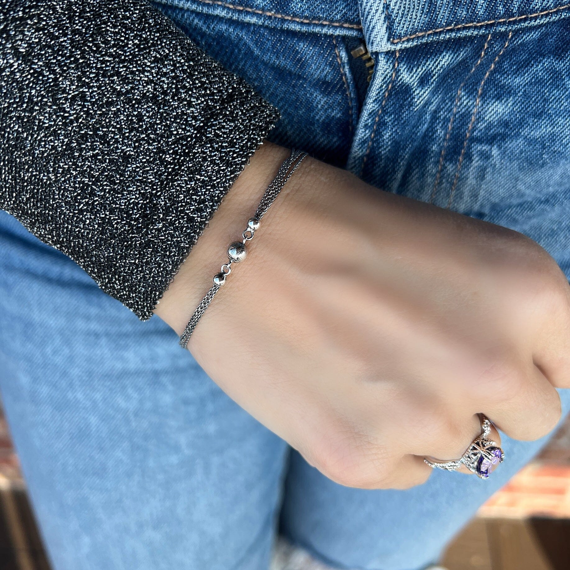 dainty silver bracelet featuring three round beads with an oxidized finish