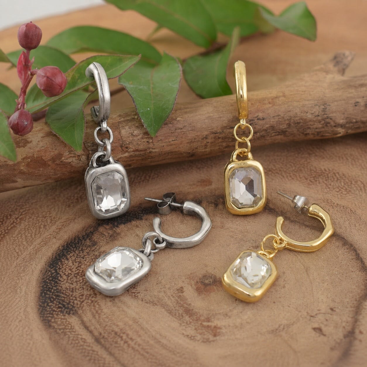2 pairs of posh boutique earrings that feature clear rectangular gemstones in silver and gold settings