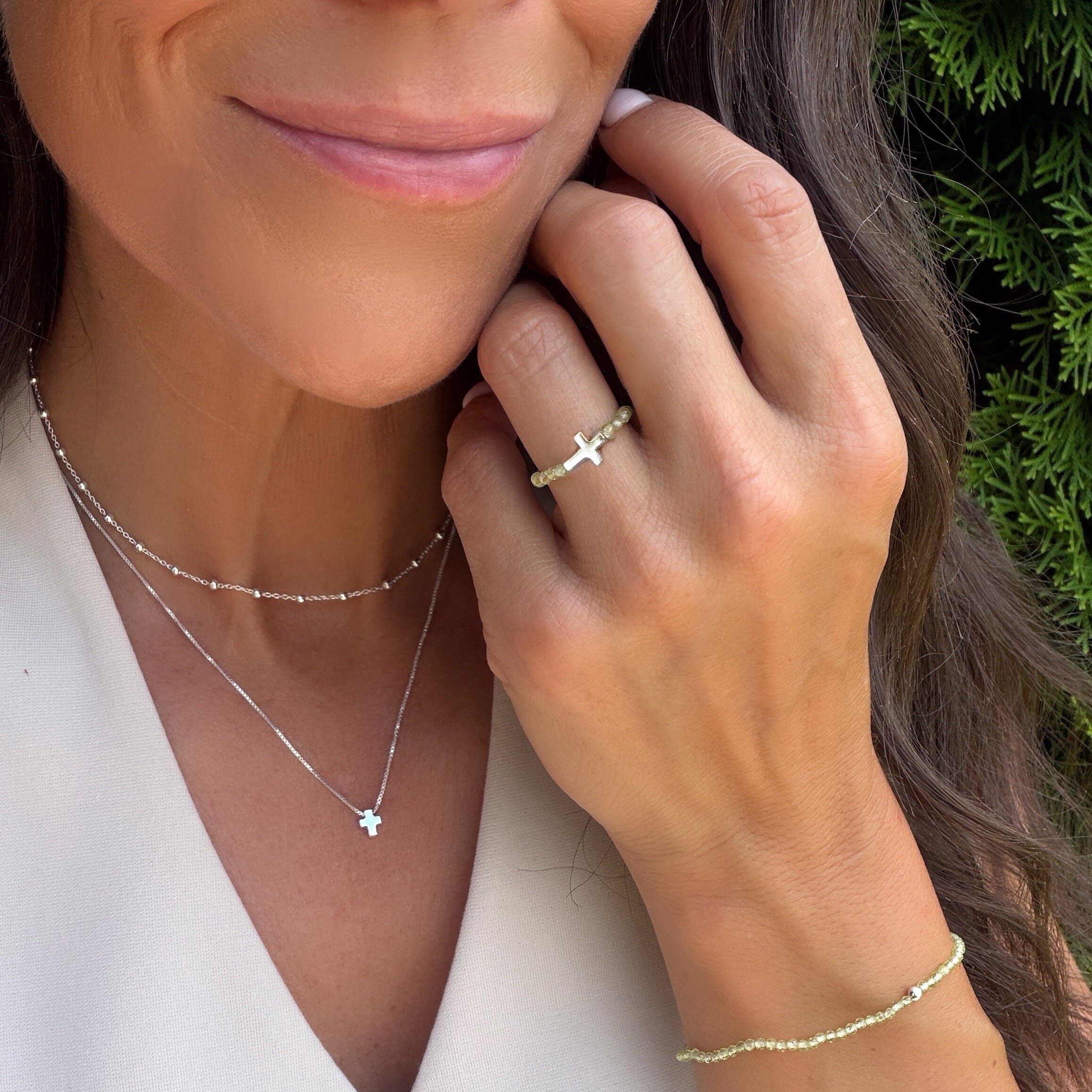 peridot beaded stretch ring featuring a cross