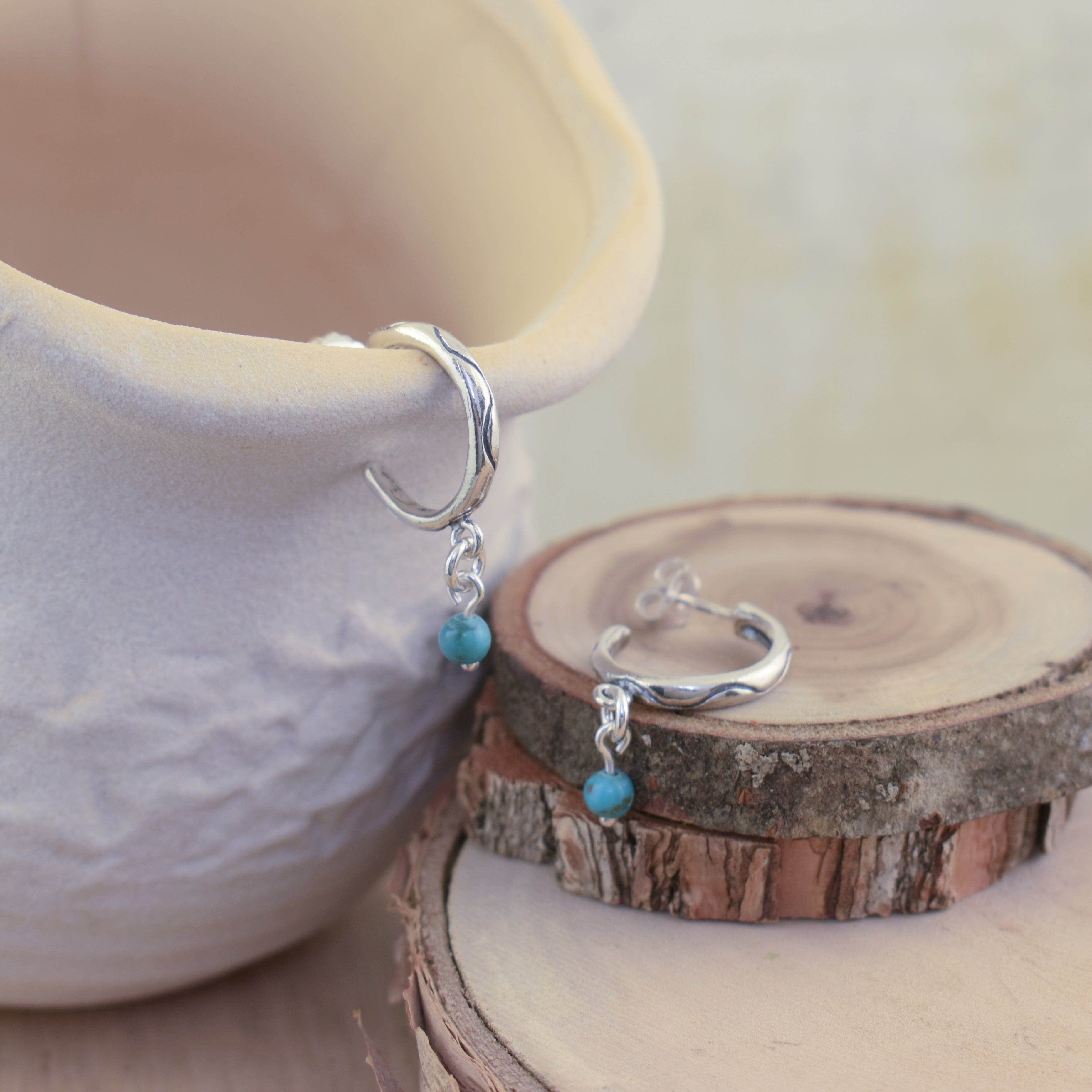 push-back post style hoops in sterling silver featuring an oxidized wave and turquoise dangle 