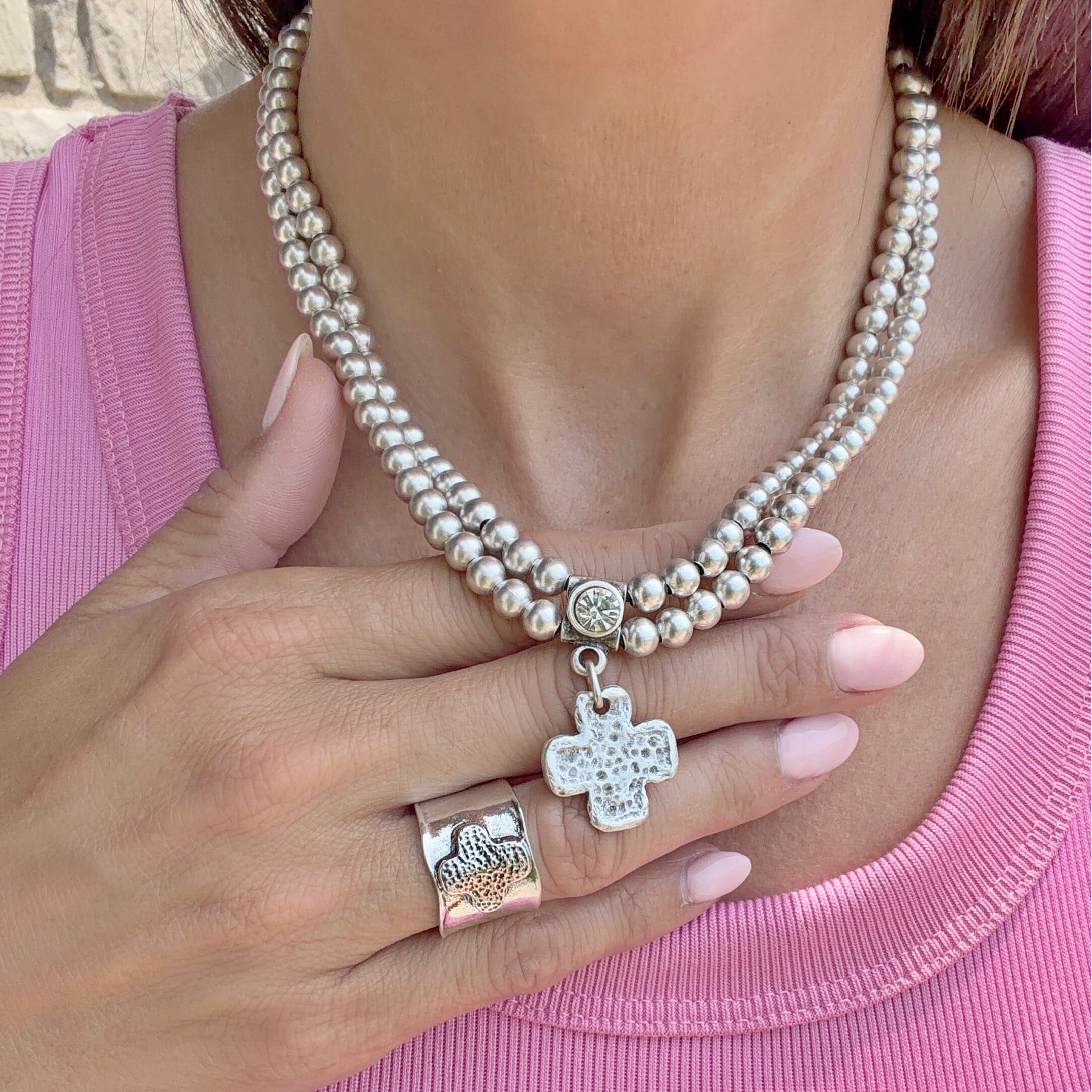 beaded necklace featuring a cz and cross pendant