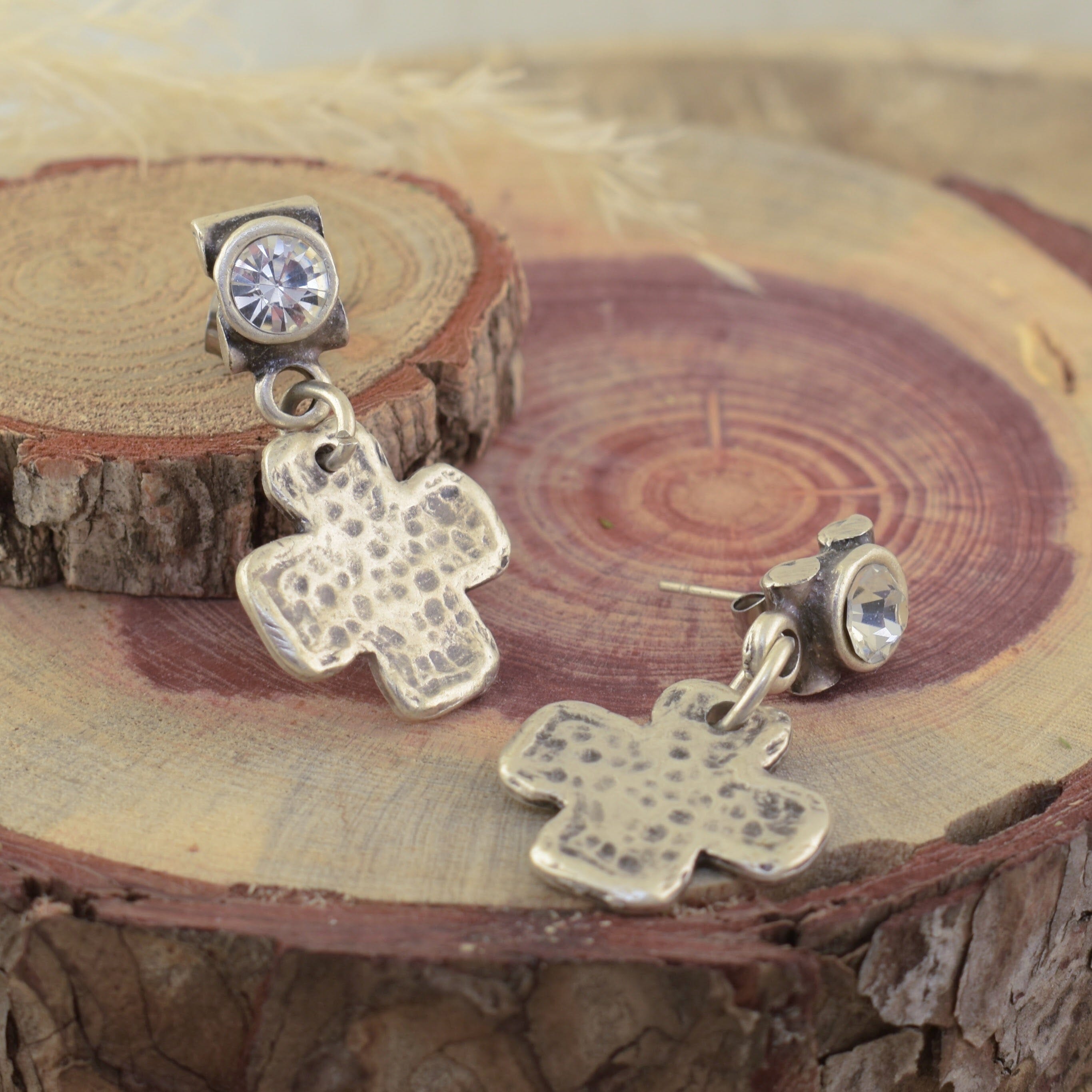 a pair of posh boutique post earrings, with a dangly hammered cross, on a CZ post.