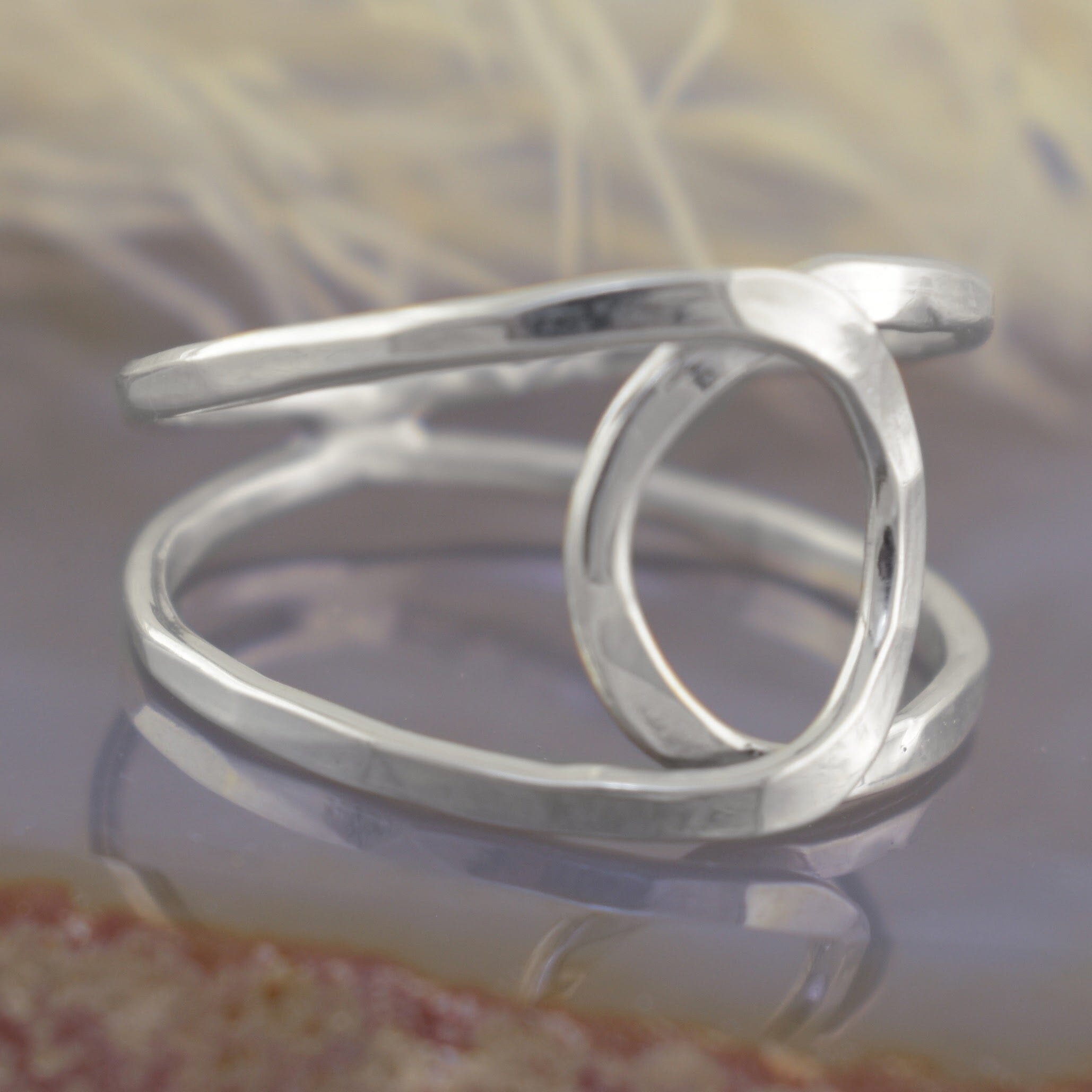 A sterling silver open wrap ring with a textured, hammered finish and organic, flowing curves