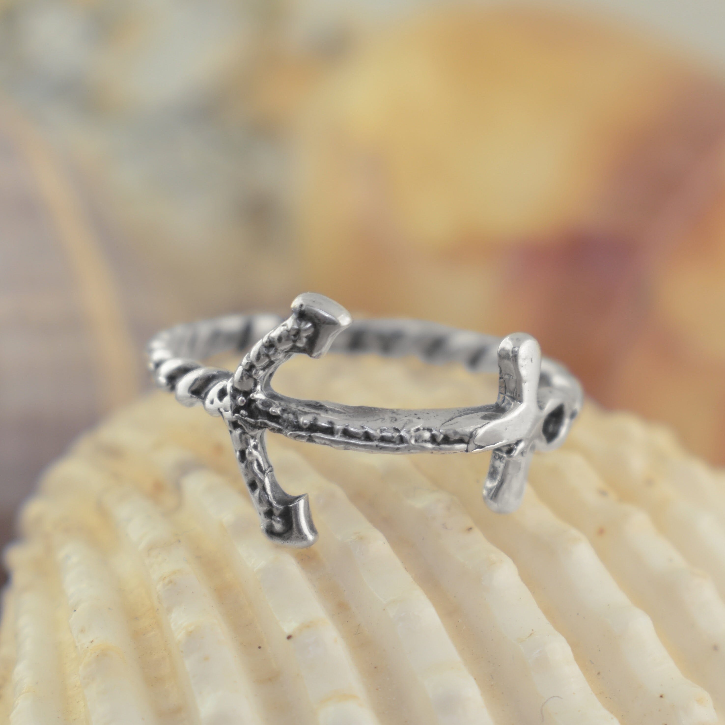 A silver anchor ring with a textured, hammered finish