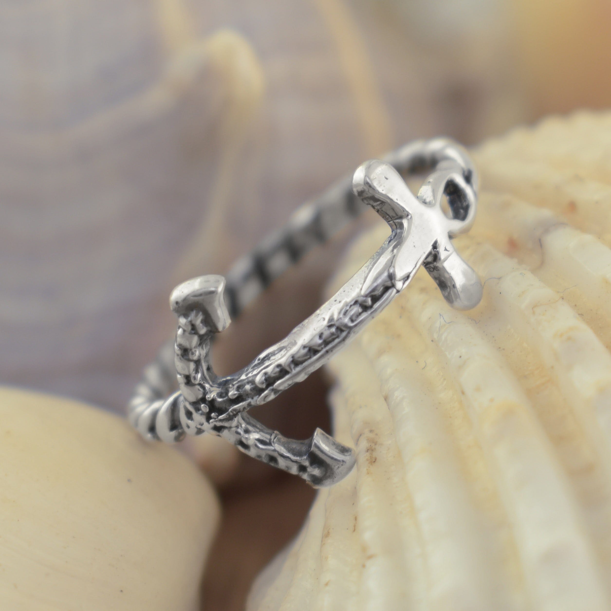 A silver anchor ring with a textured, hammered finish
