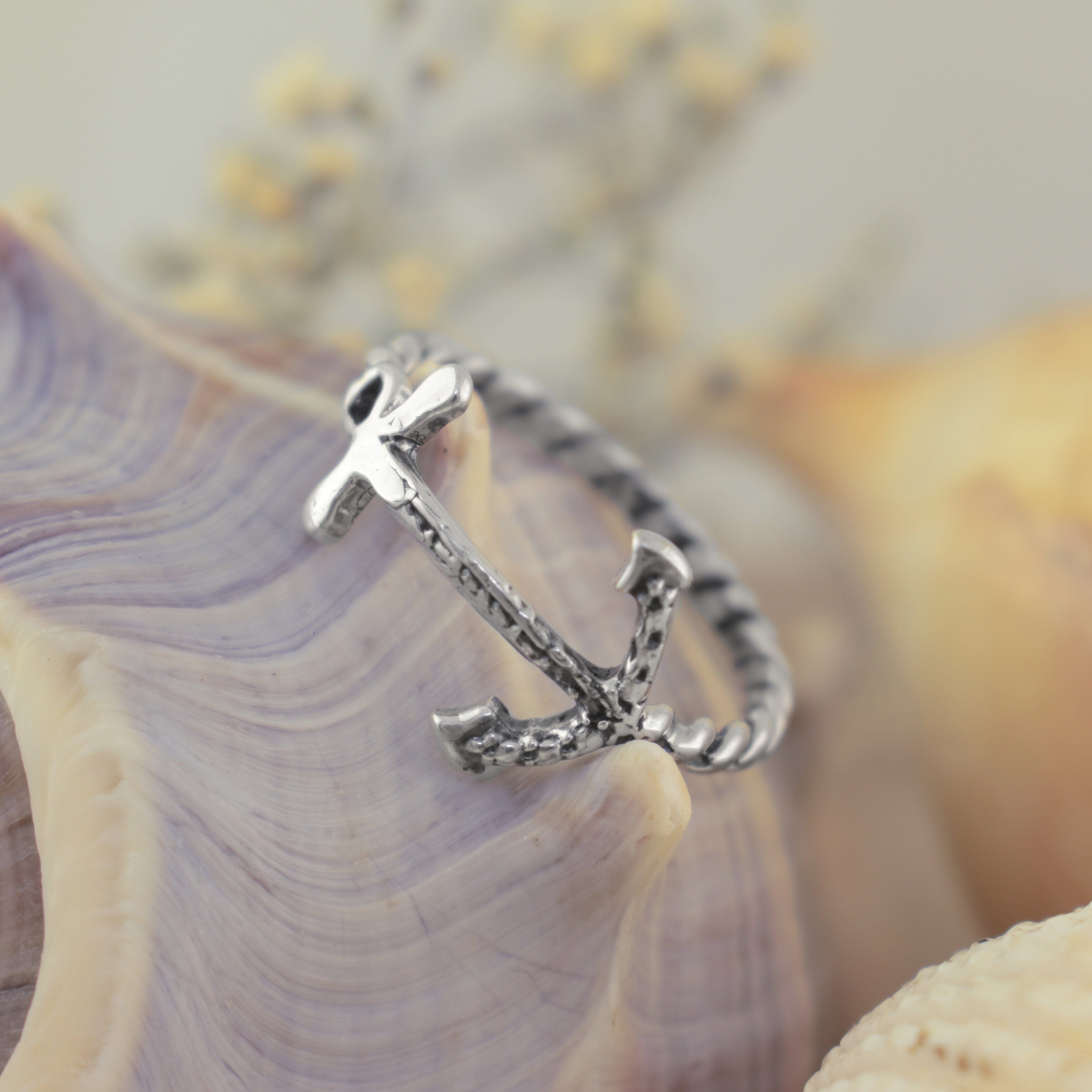 A silver anchor ring with a textured, hammered finish and a twisted band