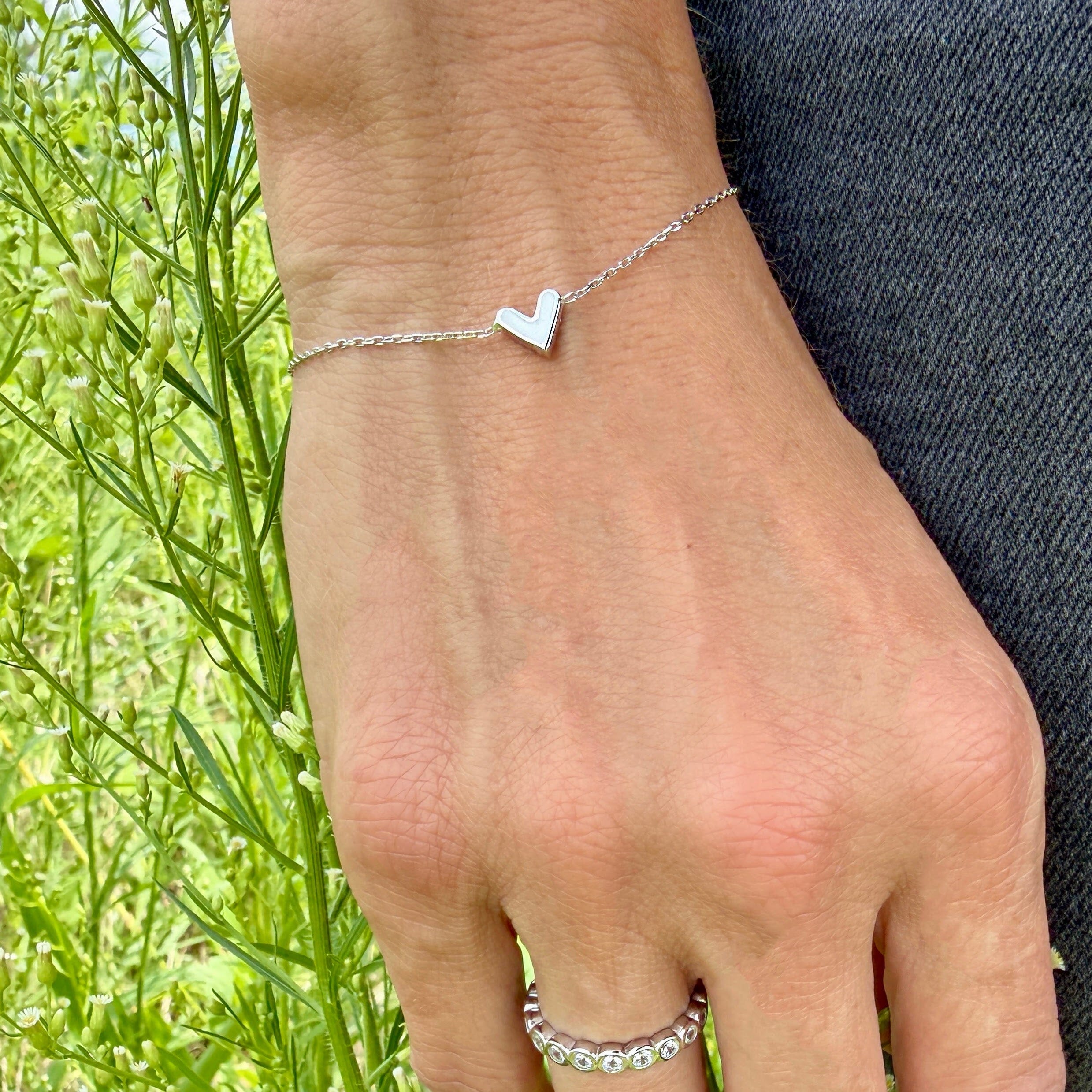 delicate sterling silver bracelet featuring a little white enamel heart pendant
