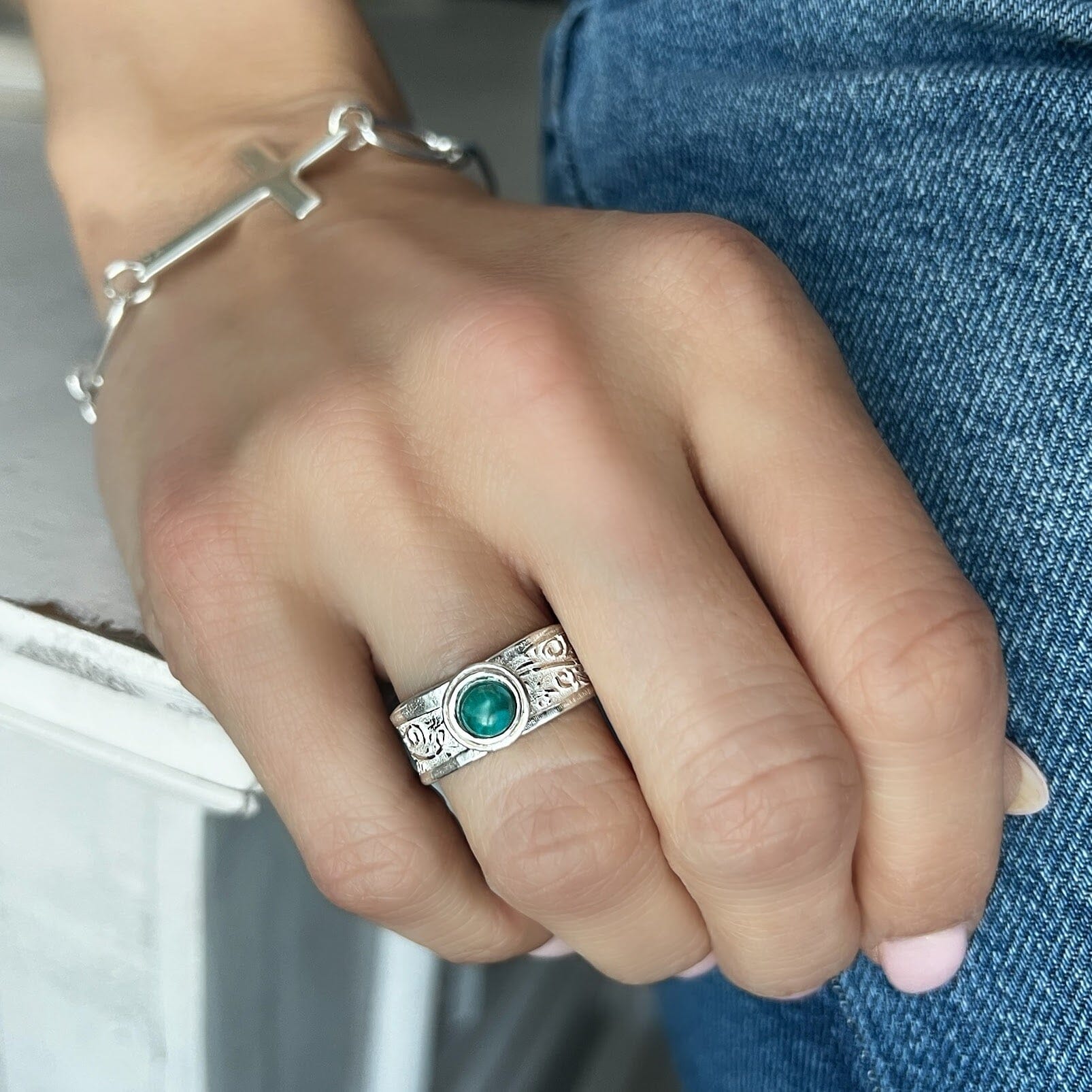 medium width silver band featuring a bezel set reconstructed turquoise center