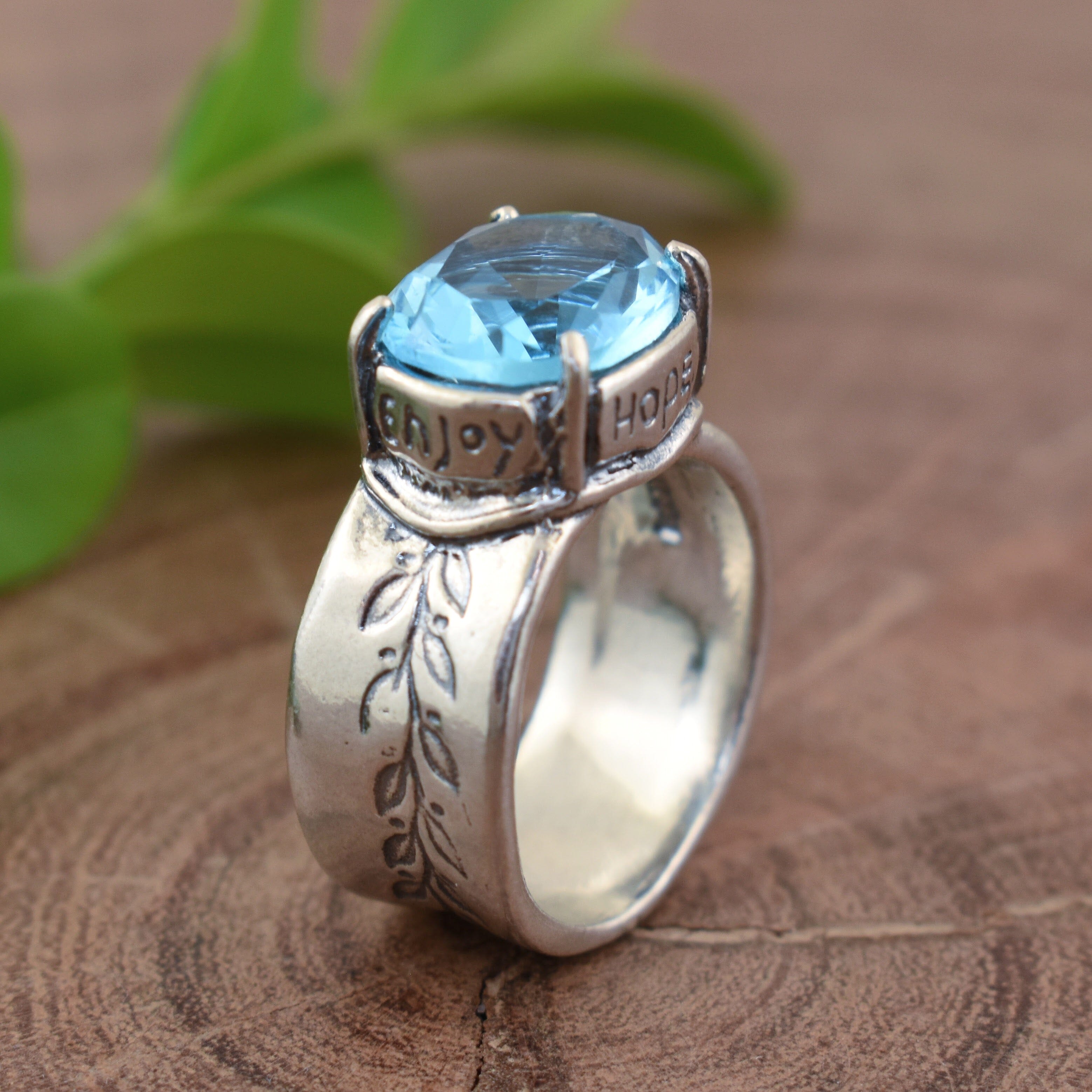 Sterling silver ring with vine detail and oval-shaped blue cubic zirconia stone