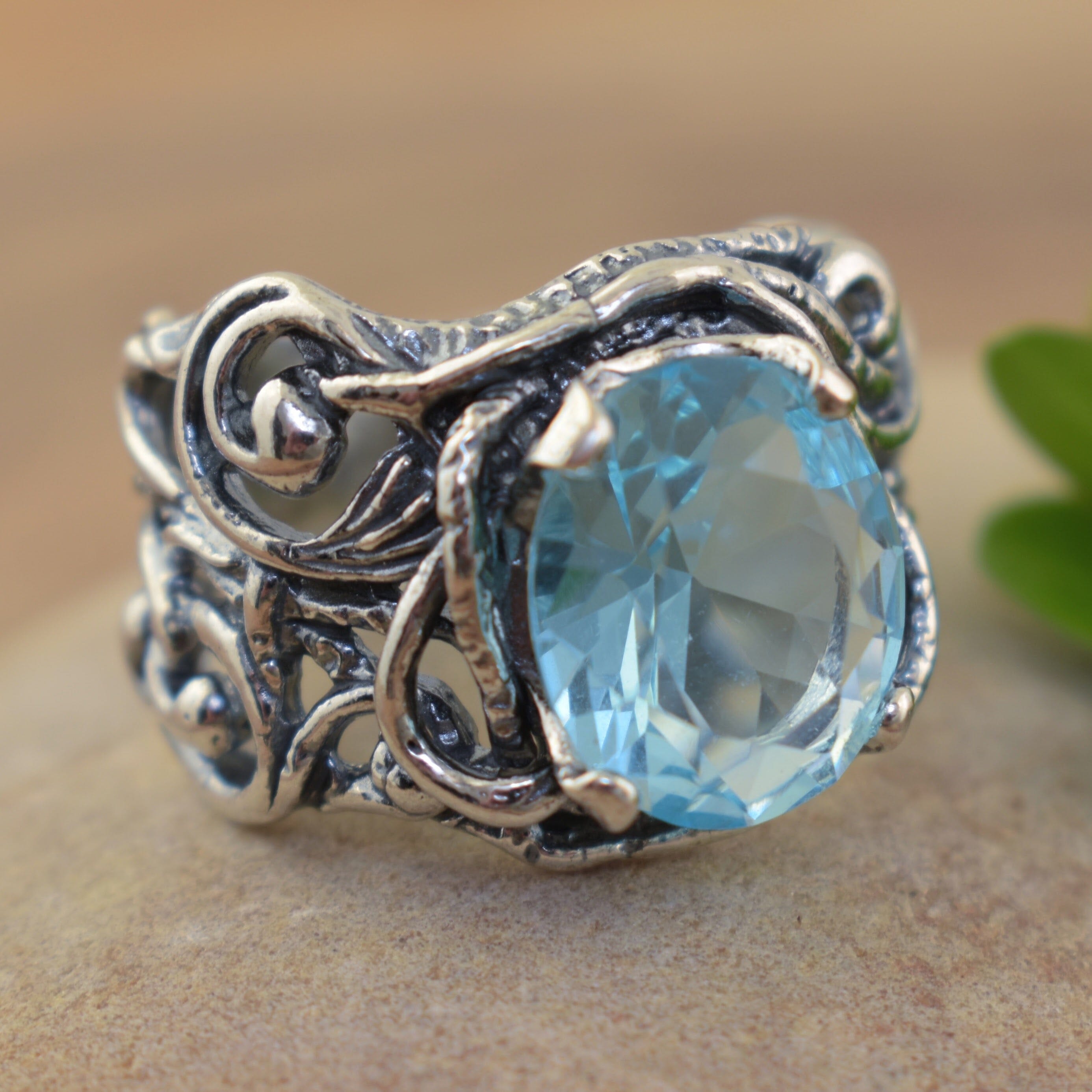 water inspired ring with a swirl designed band and blue stone