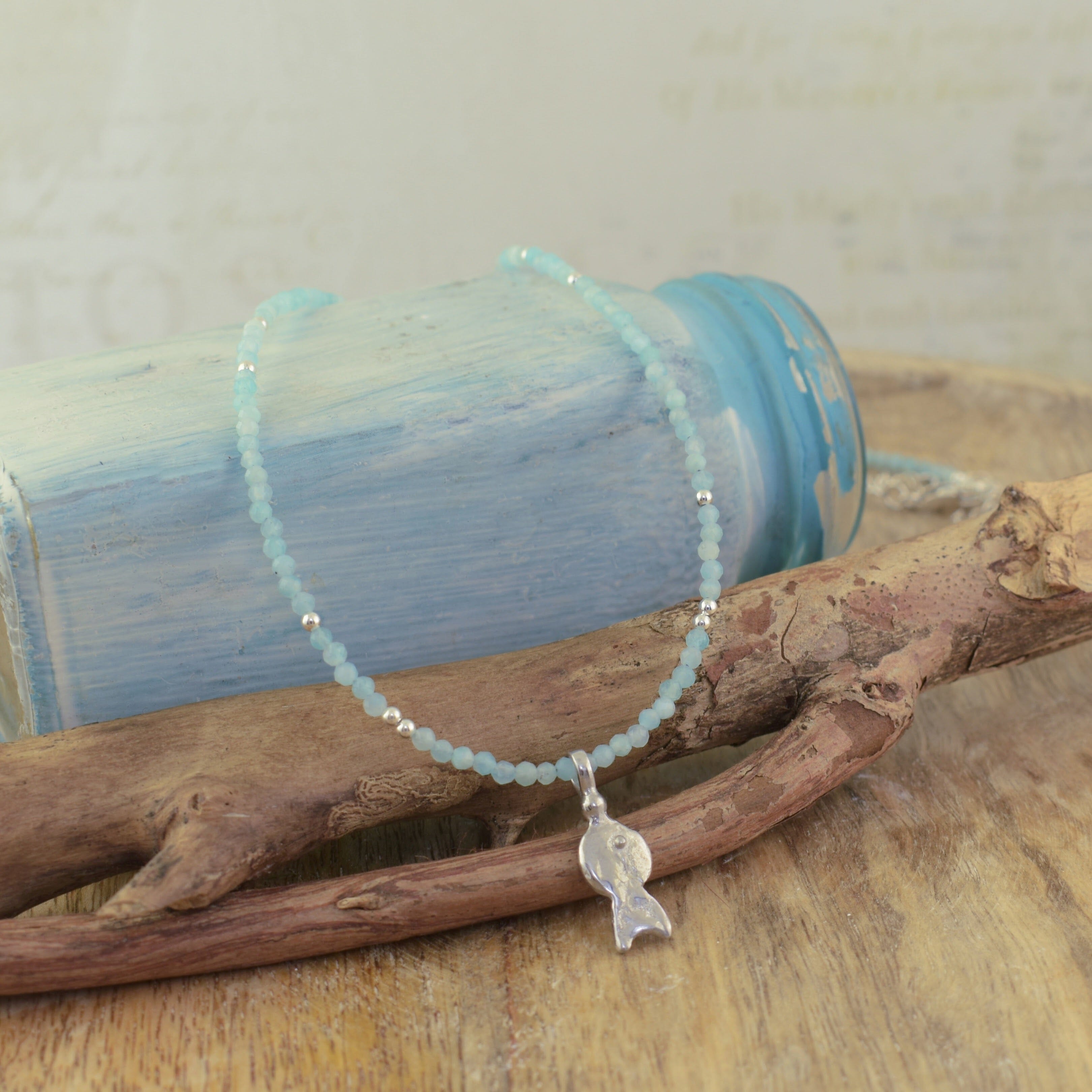 ocean colored stone necklace featuring a silver fish pendant