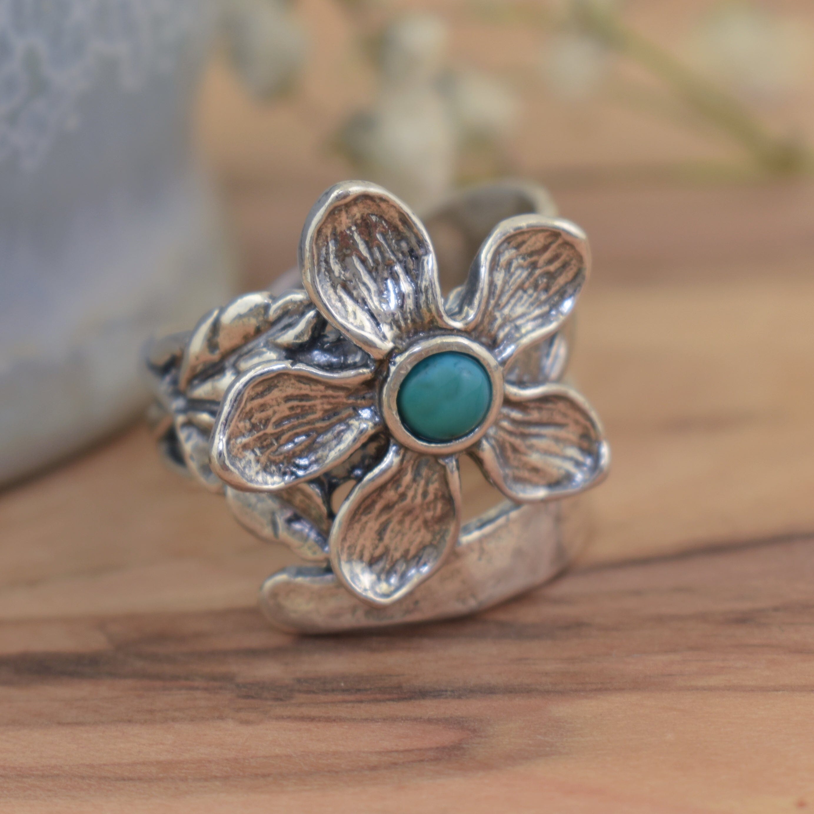 flower design ring handcrafted in sterling silver with a reconstructed turquoise center