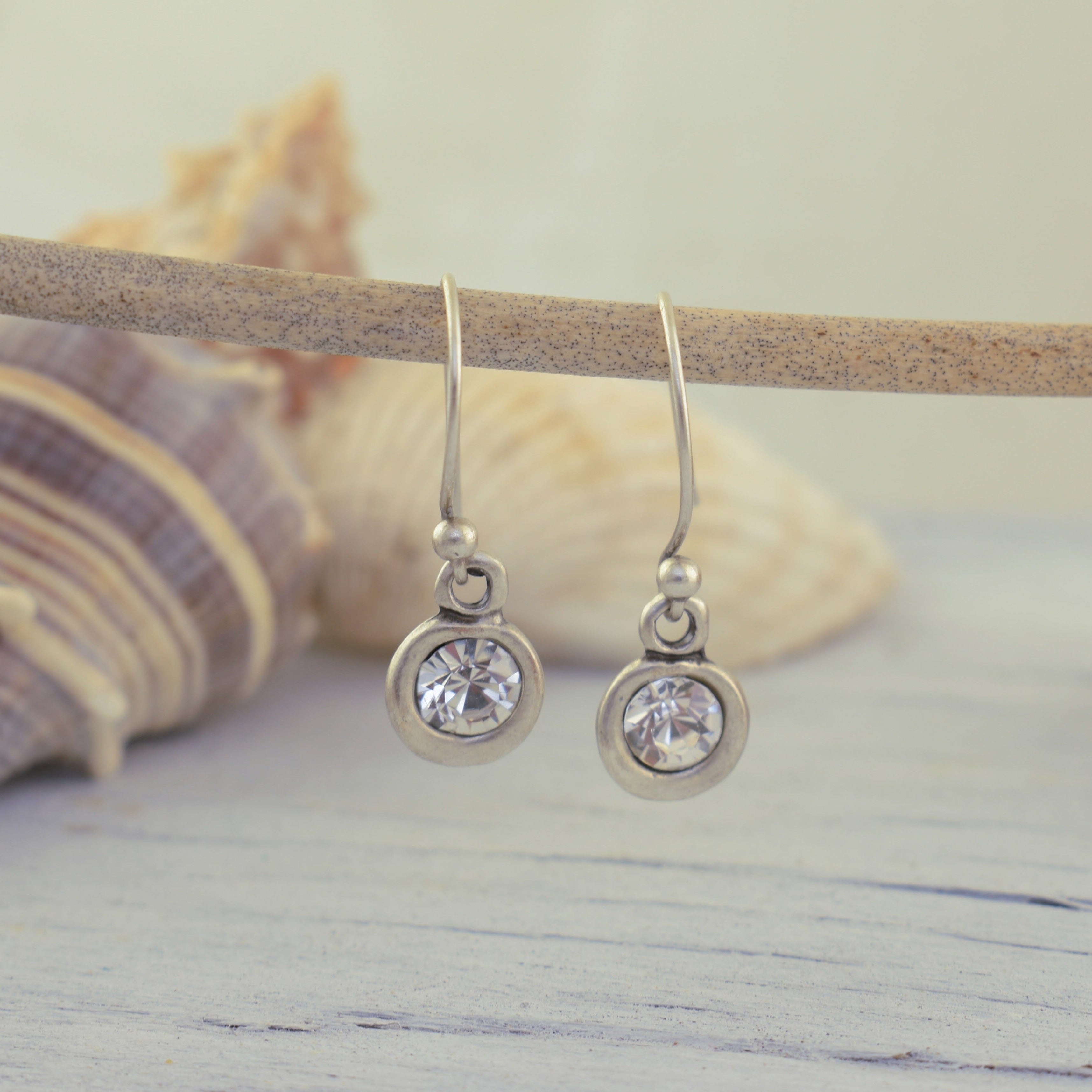 A pair of silver drop earrings with clear round clear stones