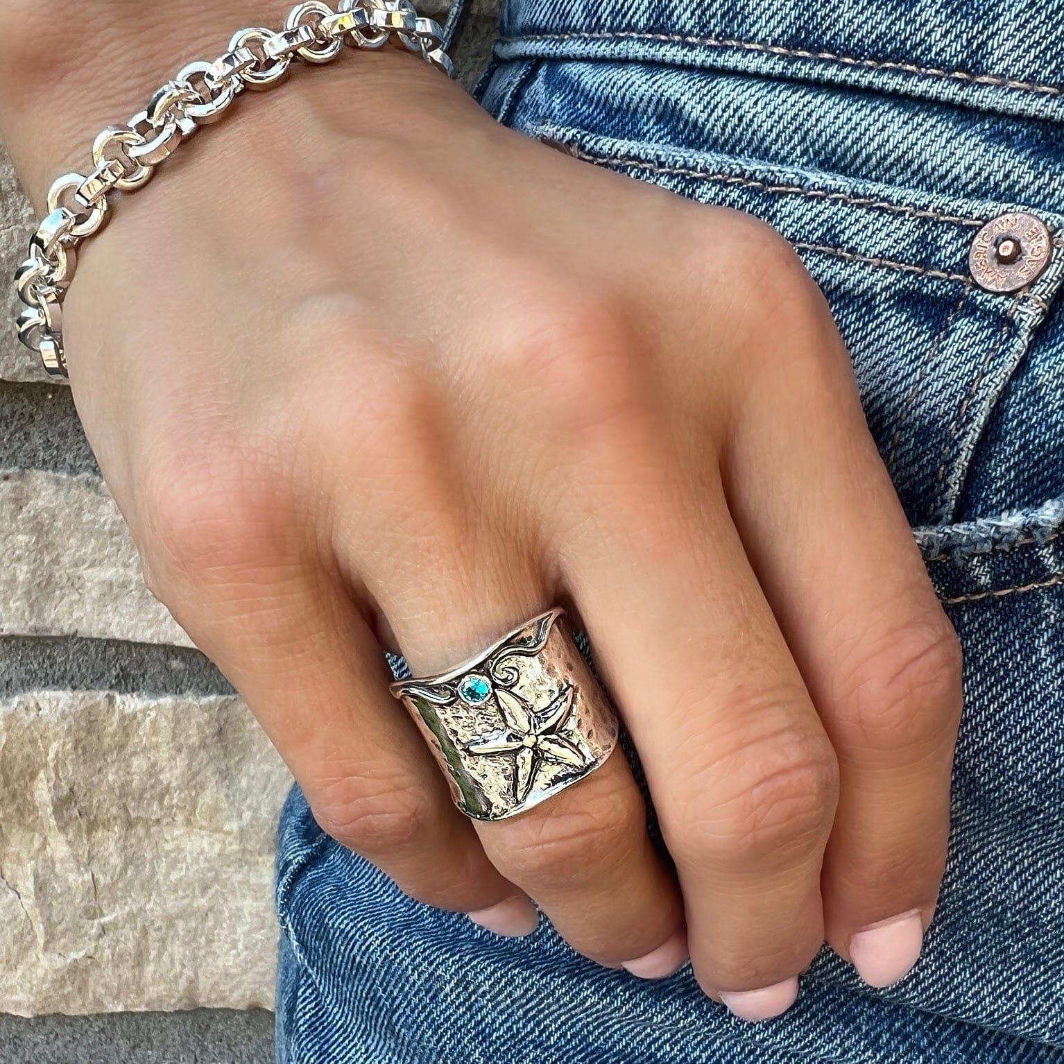 chunky silver starfish ring featuring a small blue stone