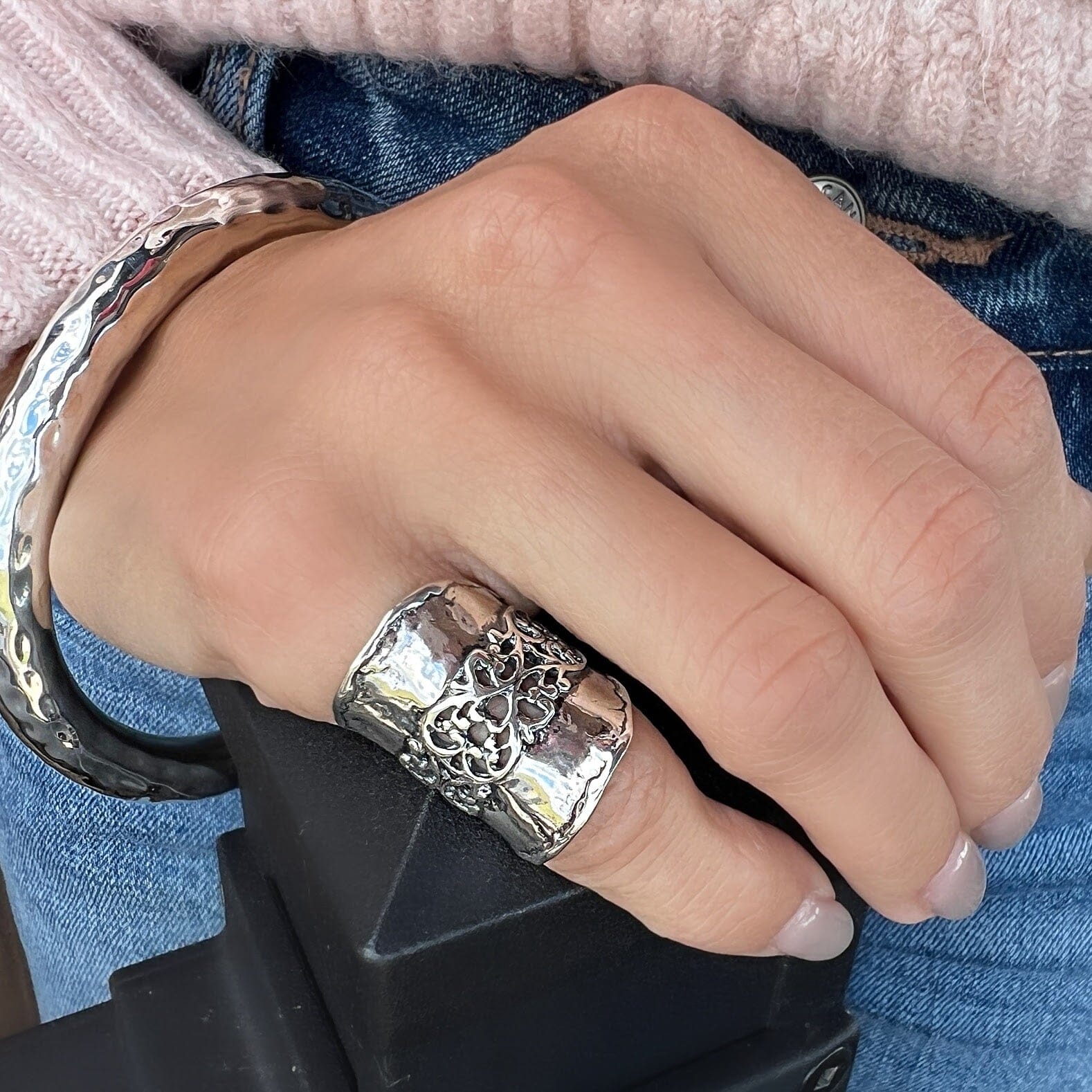 wide silver ring with open filigree swirls down the middle